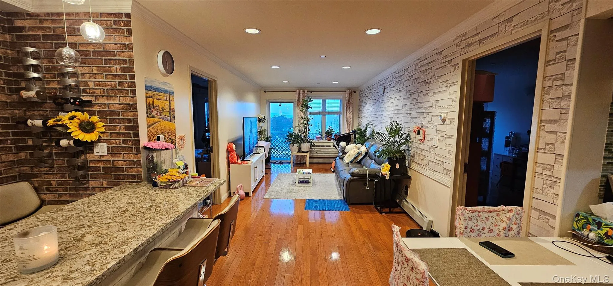 Corridor featuring crown molding, brick wall, light wood-style floors, a baseboard radiator, and recessed lighting Corridor featuring crown molding, brick wall, light wood-style floors, a baseboard radiator, and recessed lighting