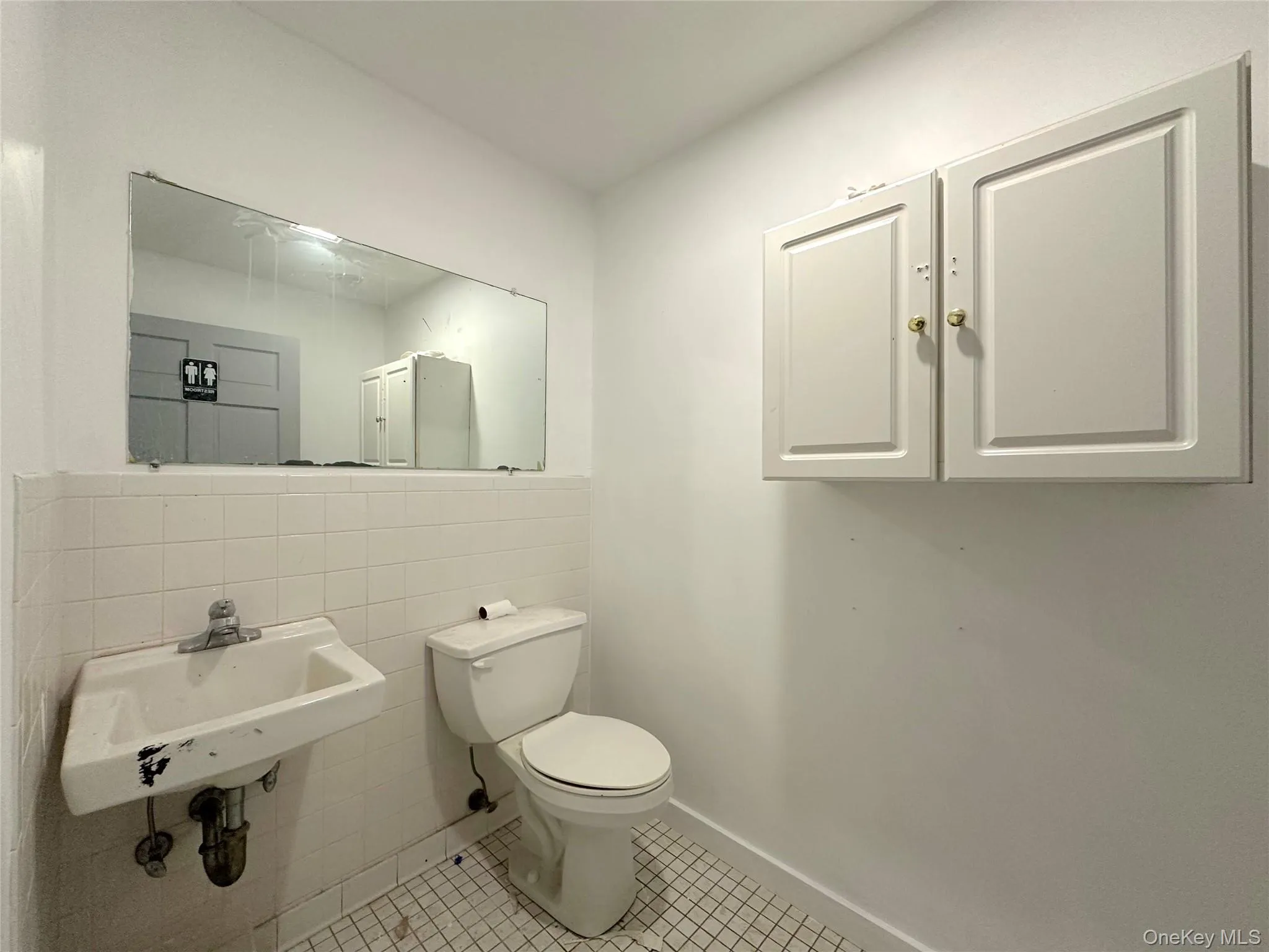 Half bath featuring tile walls and tile patterned floors Half bath featuring tile walls and tile patterned floors