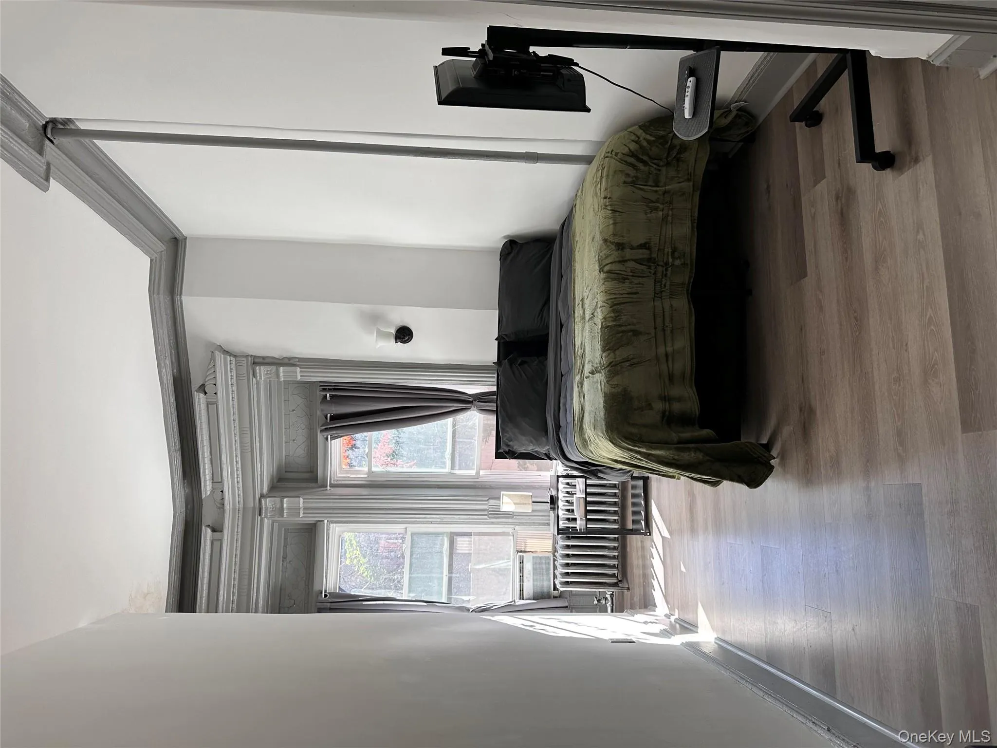 Bedroom featuring light wood-type flooring and ornamental molding Bedroom featuring light wood-type flooring and ornamental molding