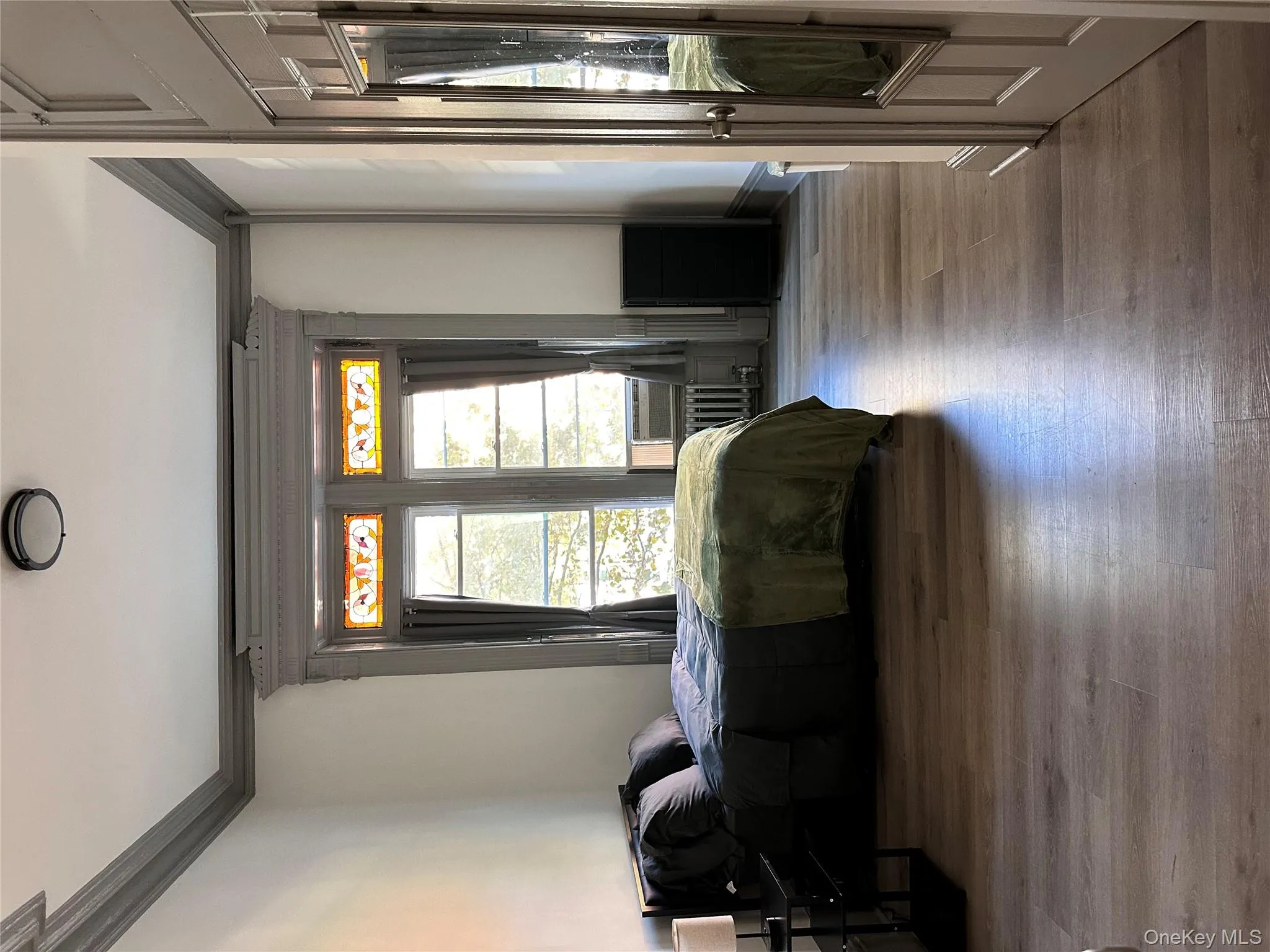 Bedroom with crown molding, wood finished floors, and radiator Bedroom with crown molding, wood finished floors, and radiator