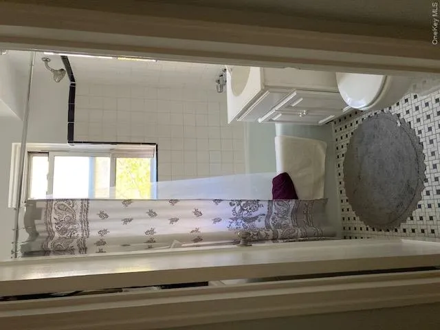 Full bath with vanity, shower / bath combo with shower curtain, and light tile patterned floors Full bath with vanity, shower / bath combo with shower curtain, and light tile patterned floors