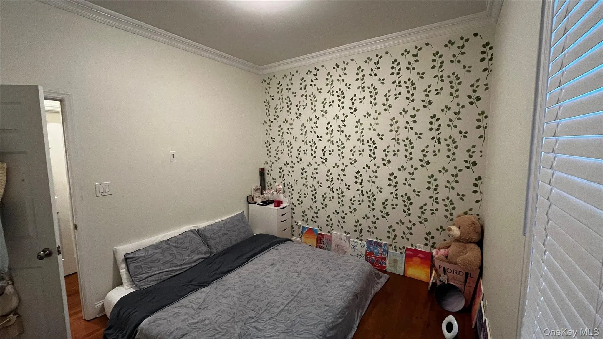 Bedroom with ornamental molding and wood finished floors Bedroom with ornamental molding and wood finished floors