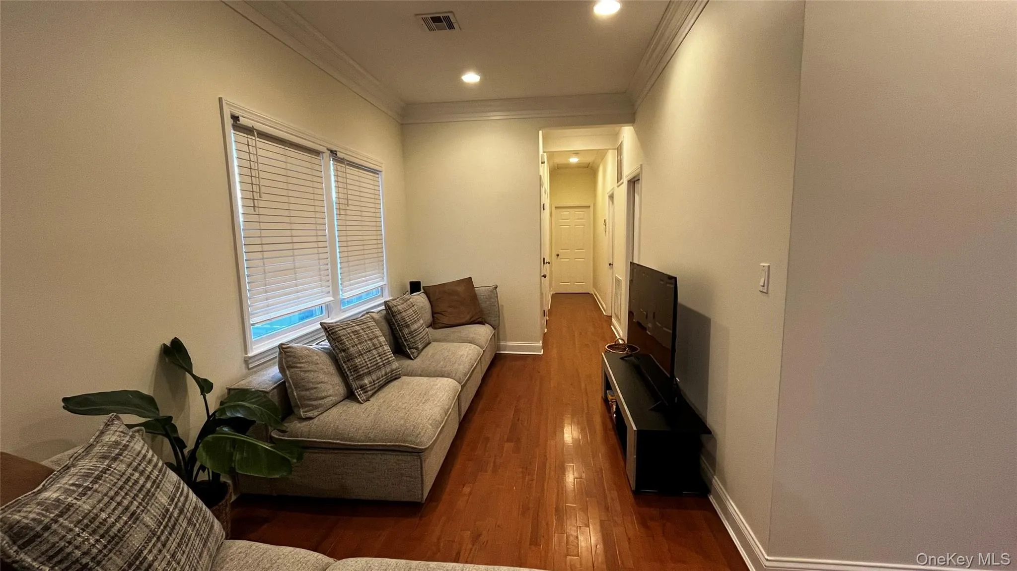 Living area featuring ornamental molding, dark wood finished floors, and recessed lighting Living area featuring ornamental molding, dark wood finished floors, and recessed lighting