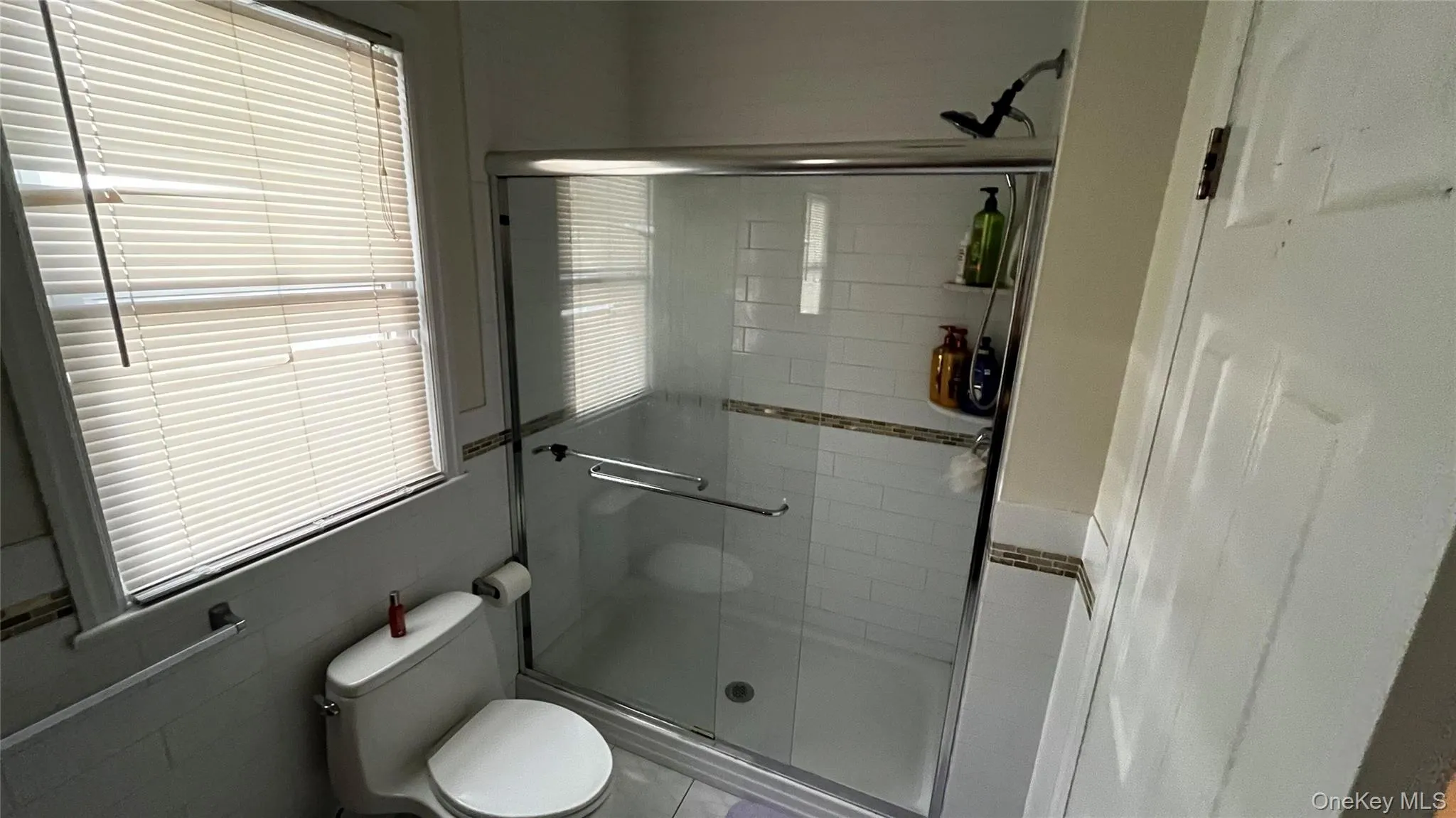 Bathroom featuring a stall shower and healthy amount of natural light Bathroom featuring a stall shower and healthy amount of natural light