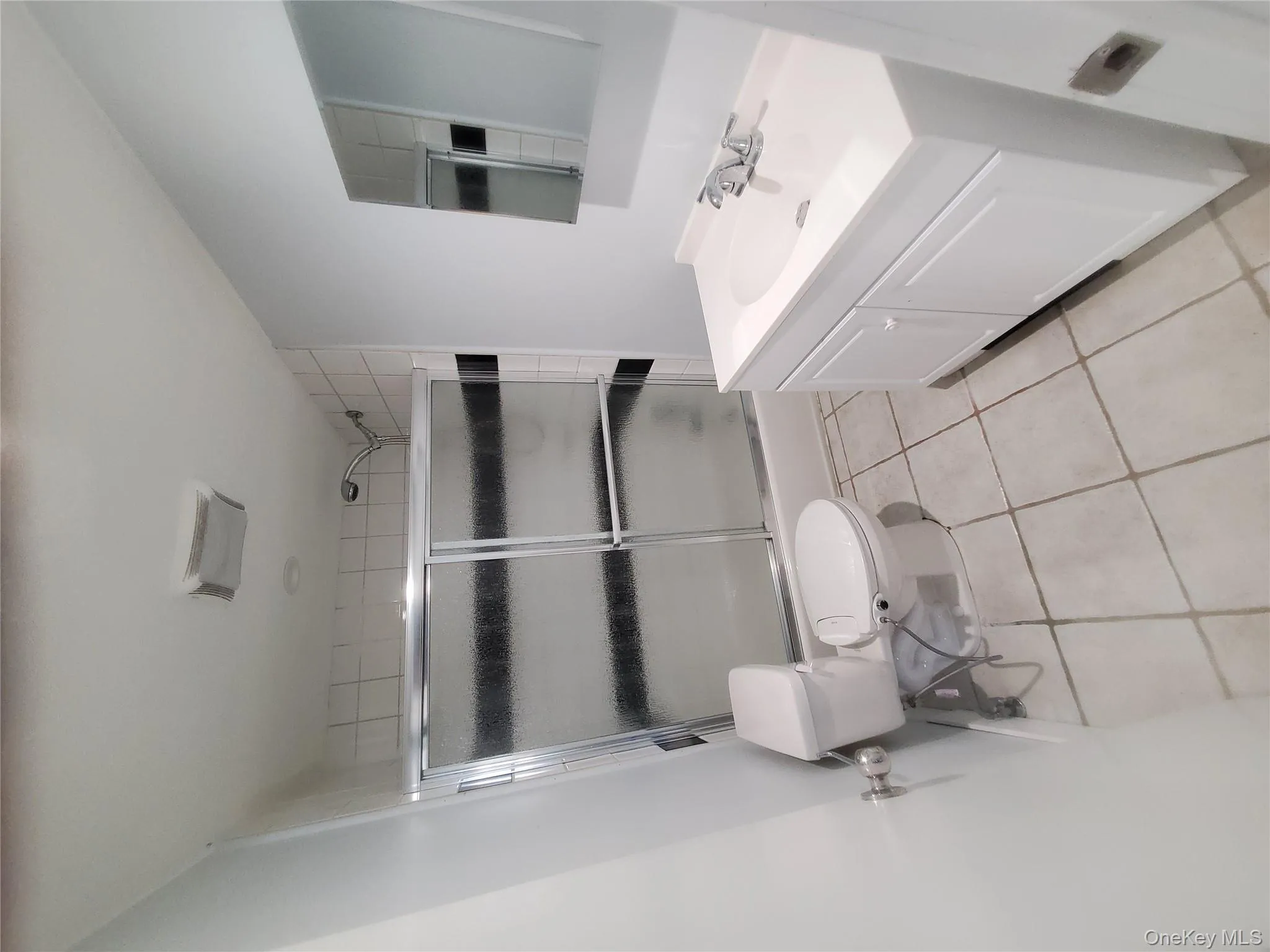 Full bathroom featuring vanity, light tile patterned floors, and shower / bath combination with glass door Full bathroom featuring vanity, light tile patterned floors, and shower / bath combination with glass door
