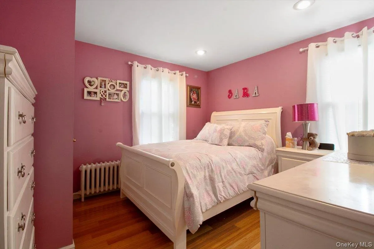 Bedroom with radiator and light wood-type flooring Bedroom with radiator and light wood-type flooring