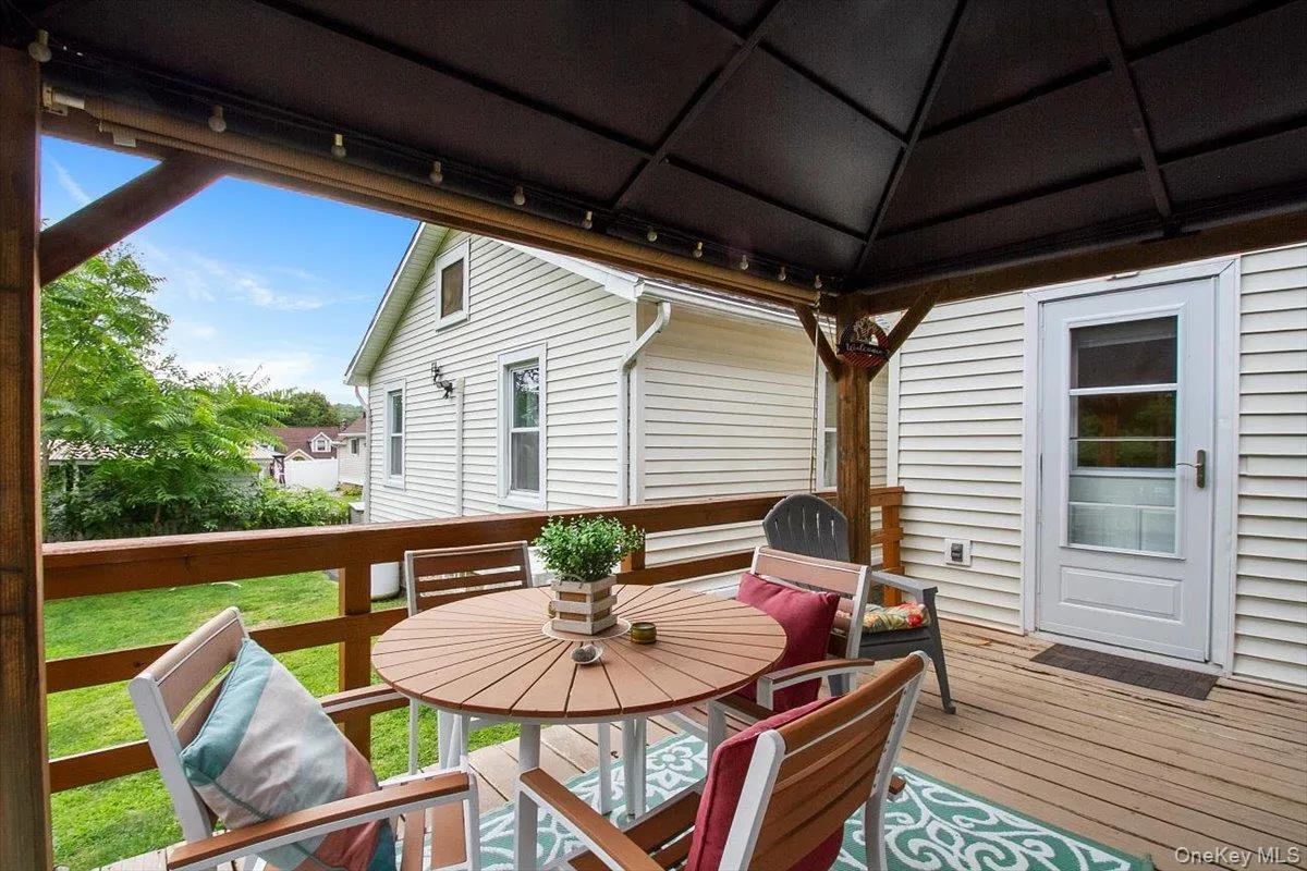 Wooden terrace featuring outdoor dining space and a gazebo Wooden terrace featuring outdoor dining space and a gazebo