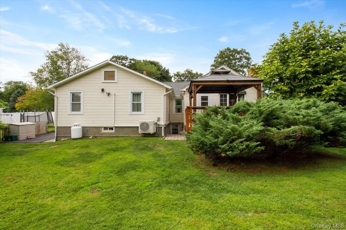 Back of property with a gazebo, a wooden deck, and a patio area Back of property with a gazebo, a wooden deck, and a patio area