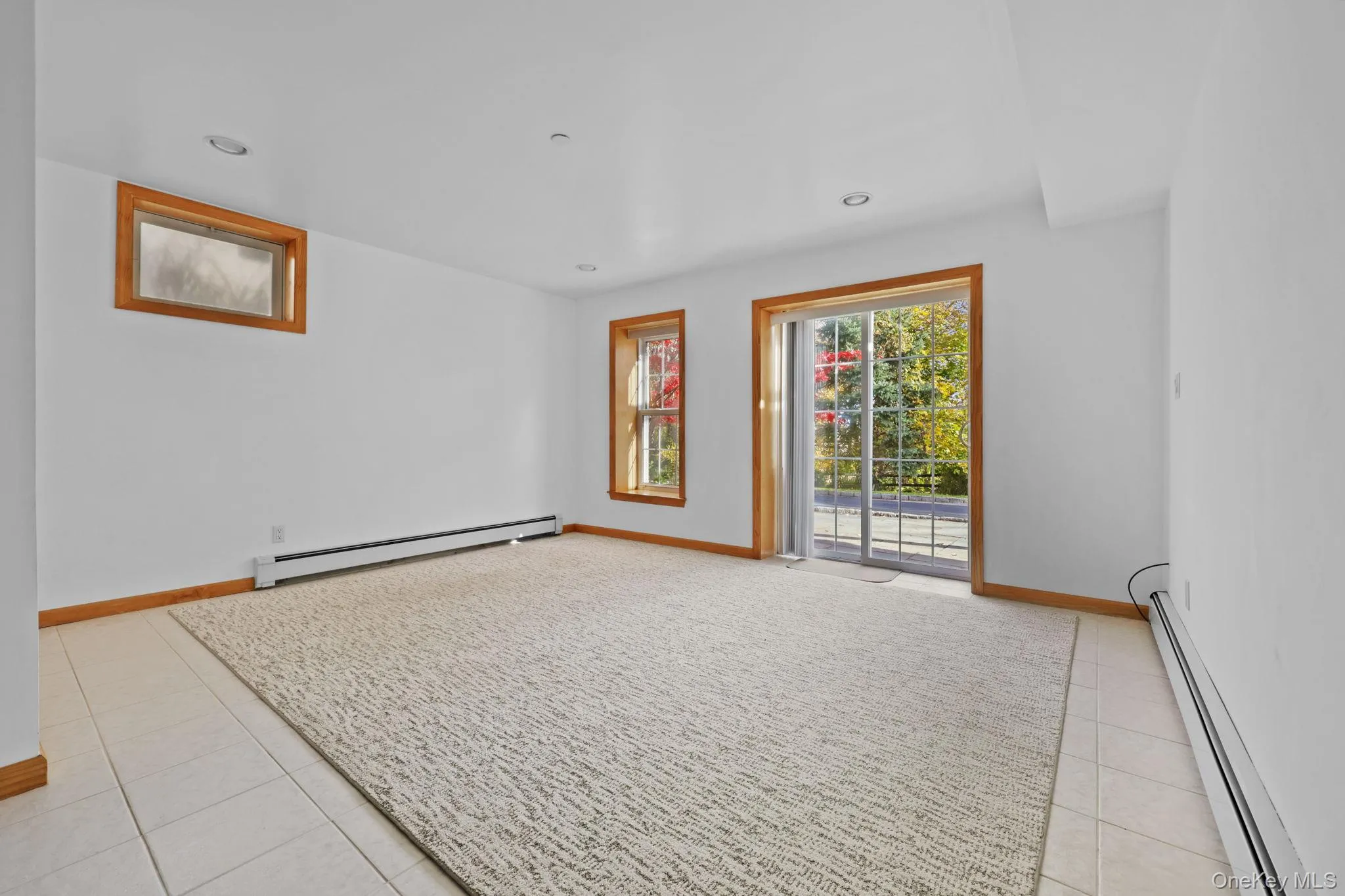 Unfurnished room with a baseboard heating unit, light tile patterned floors, and recessed lighting Unfurnished room with a baseboard heating unit, light tile patterned floors, and recessed lighting