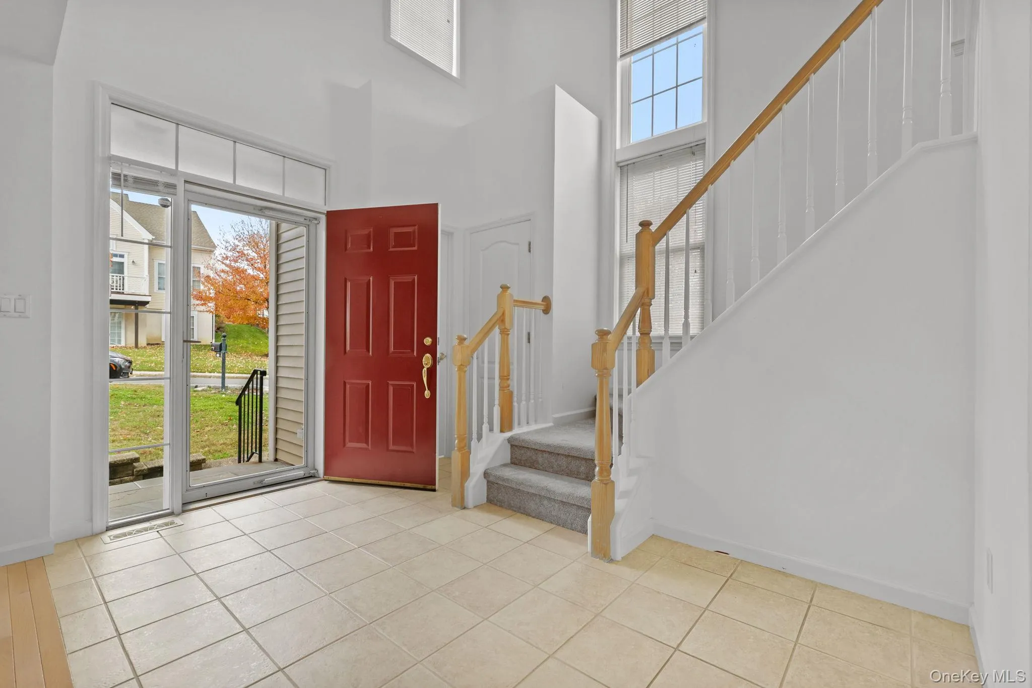 Foyer entrance with a high ceiling, stairs, and light tile patterned floors Foyer entrance with a high ceiling, stairs, and light tile patterned floors
