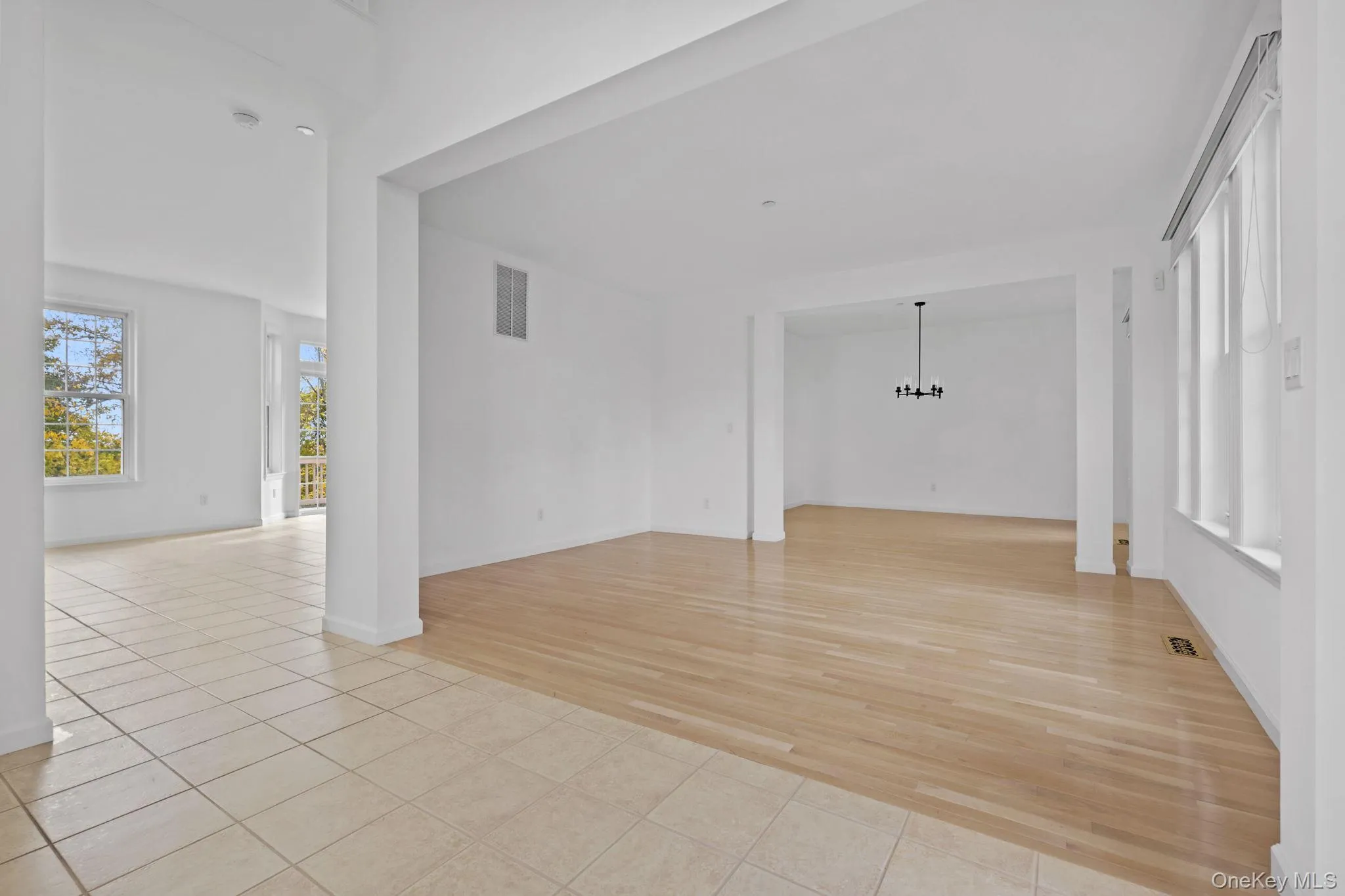 Unfurnished room with light tile patterned flooring and a chandelier Unfurnished room with light tile patterned flooring and a chandelier