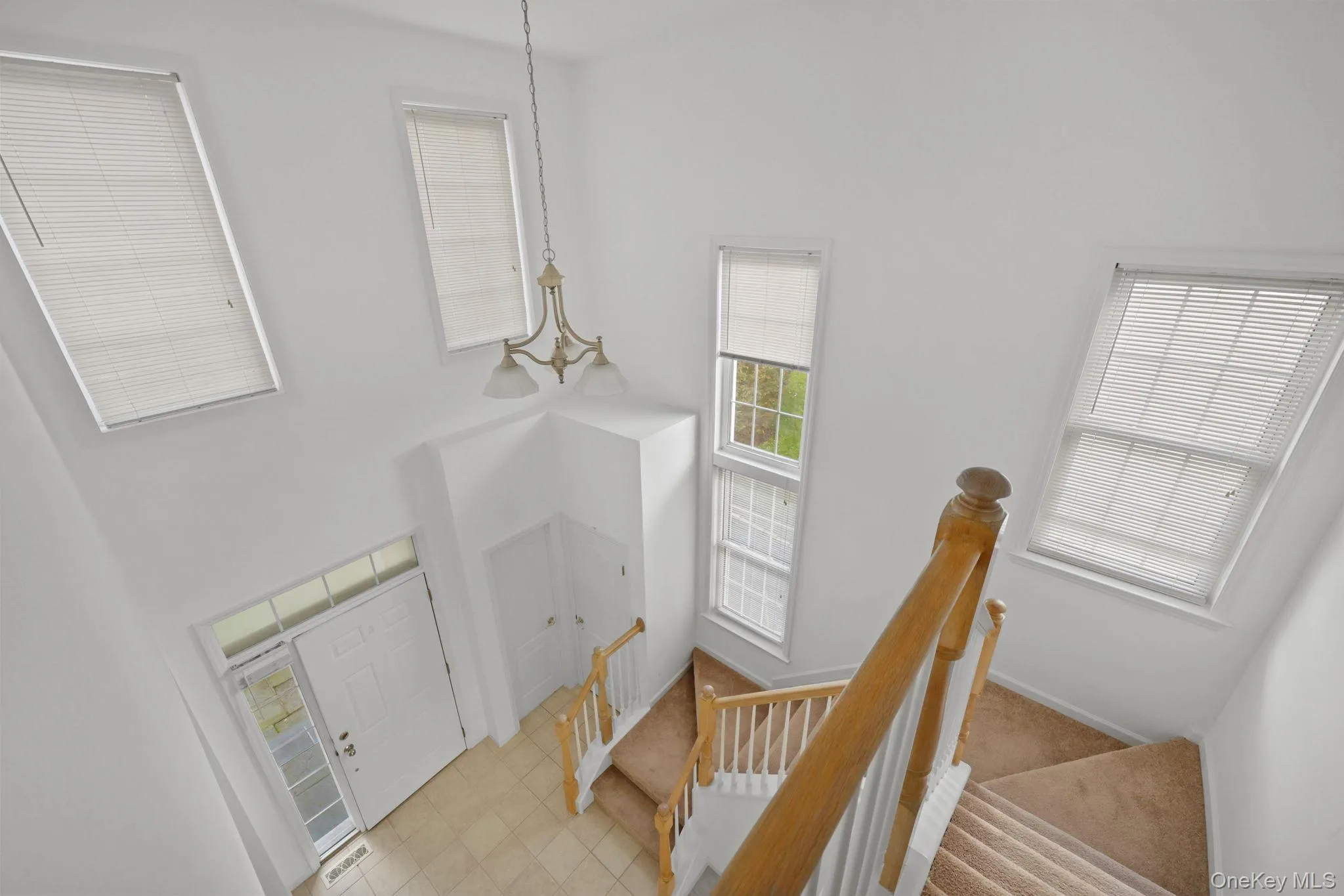 Entryway featuring a high ceiling and stairs Entryway featuring a high ceiling and stairs
