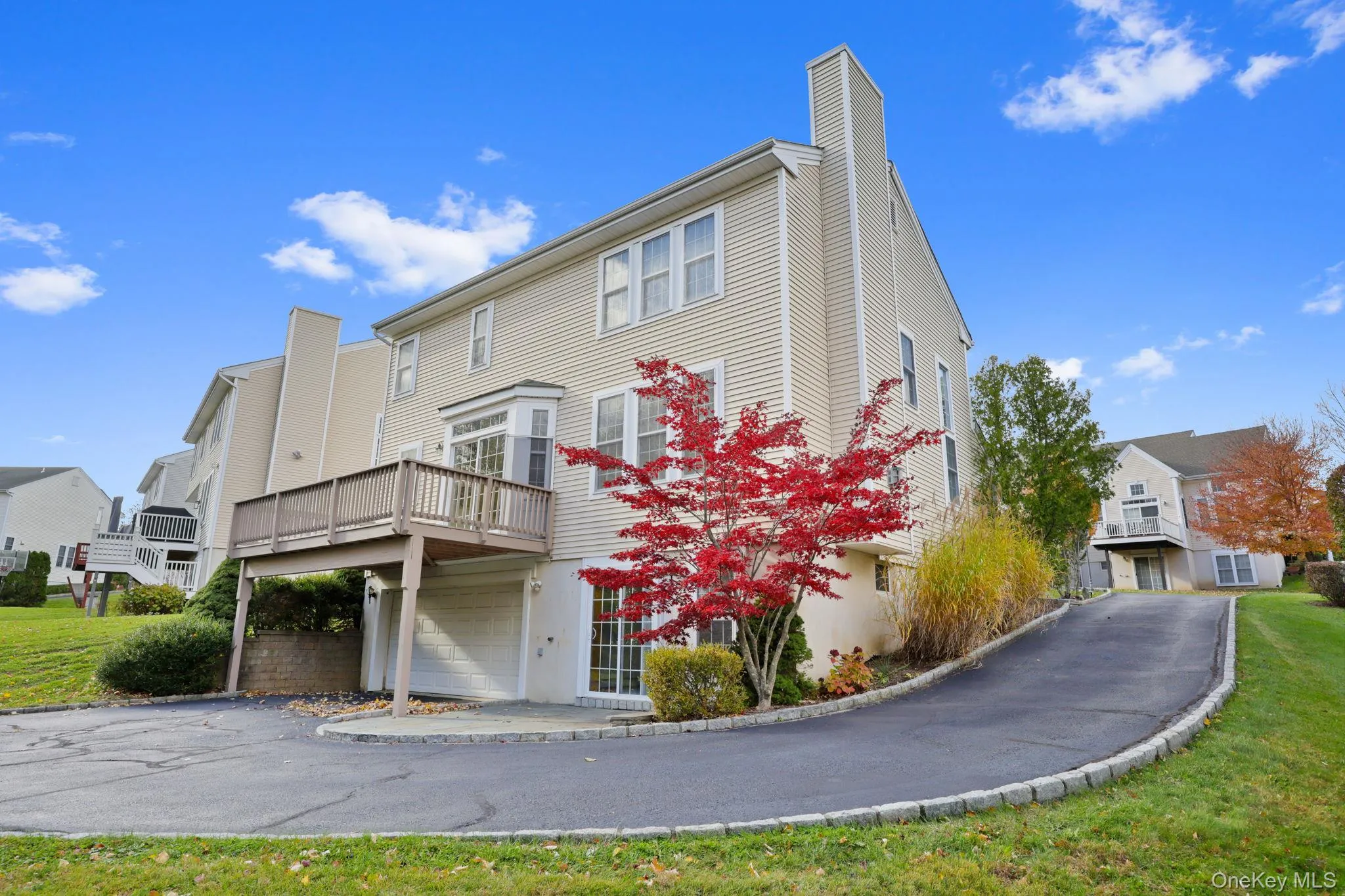 Back of property featuring a chimney, a yard, a residential view, and a garage Back of property featuring a chimney, a yard, a residential view, and a garage