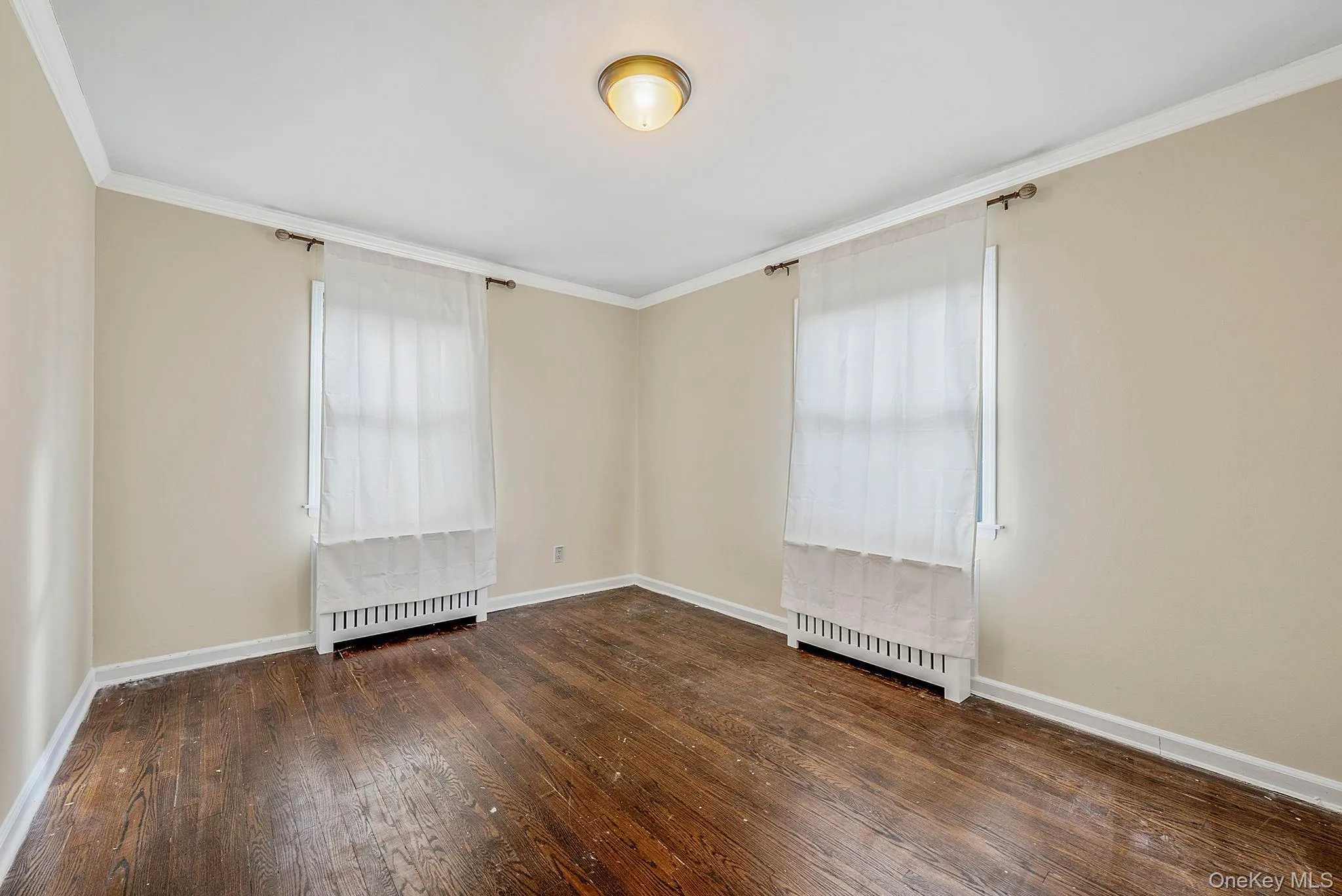 Spare room with ornamental molding and dark wood-style floors Spare room with ornamental molding and dark wood-style floors