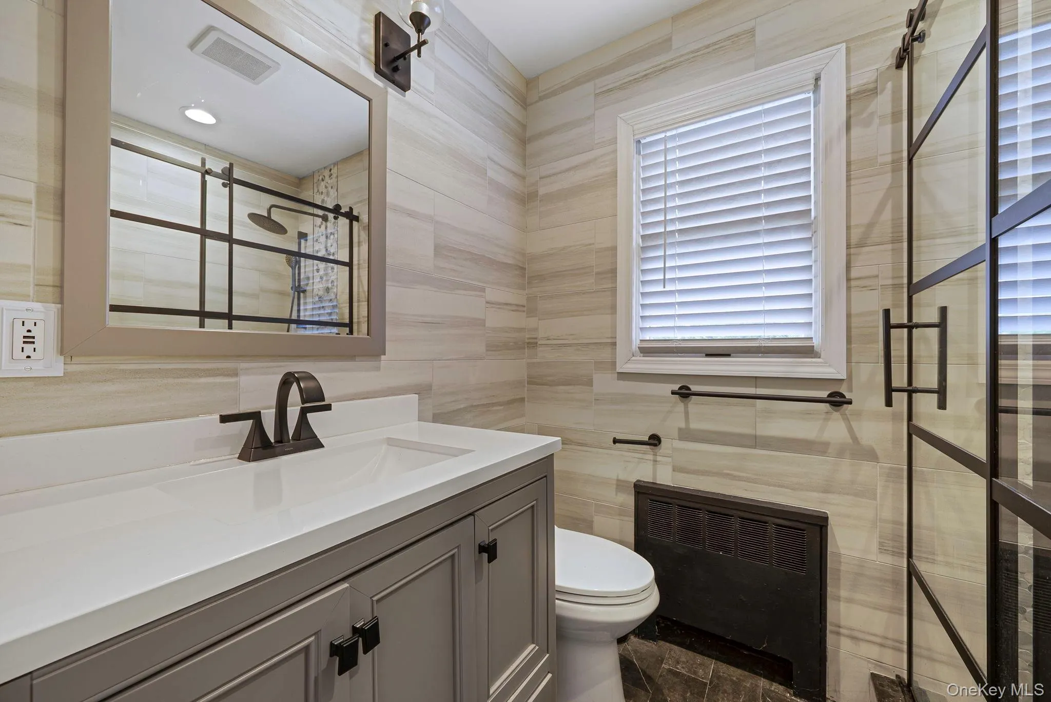 Full bath with tile walls, vanity, and heating unit Full bath with tile walls, vanity, and heating unit