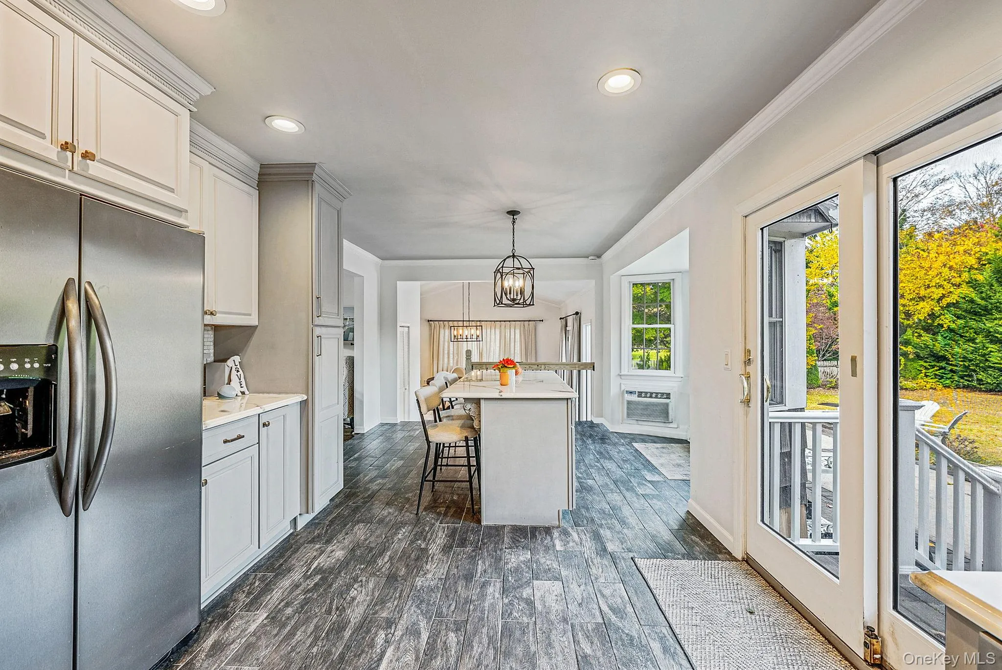 Kitchen with stainless steel fridge with ice dispenser, recessed lighting, decorative light fixtures, dark wood-type flooring, and a chandelier Kitchen with stainless steel fridge with ice dispenser, recessed lighting, decorative light fixtures, dark wood-type flooring, and a chandelier