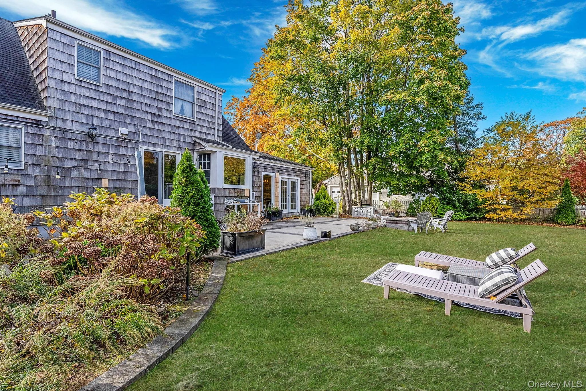 View of green lawn featuring a patio View of green lawn featuring a patio