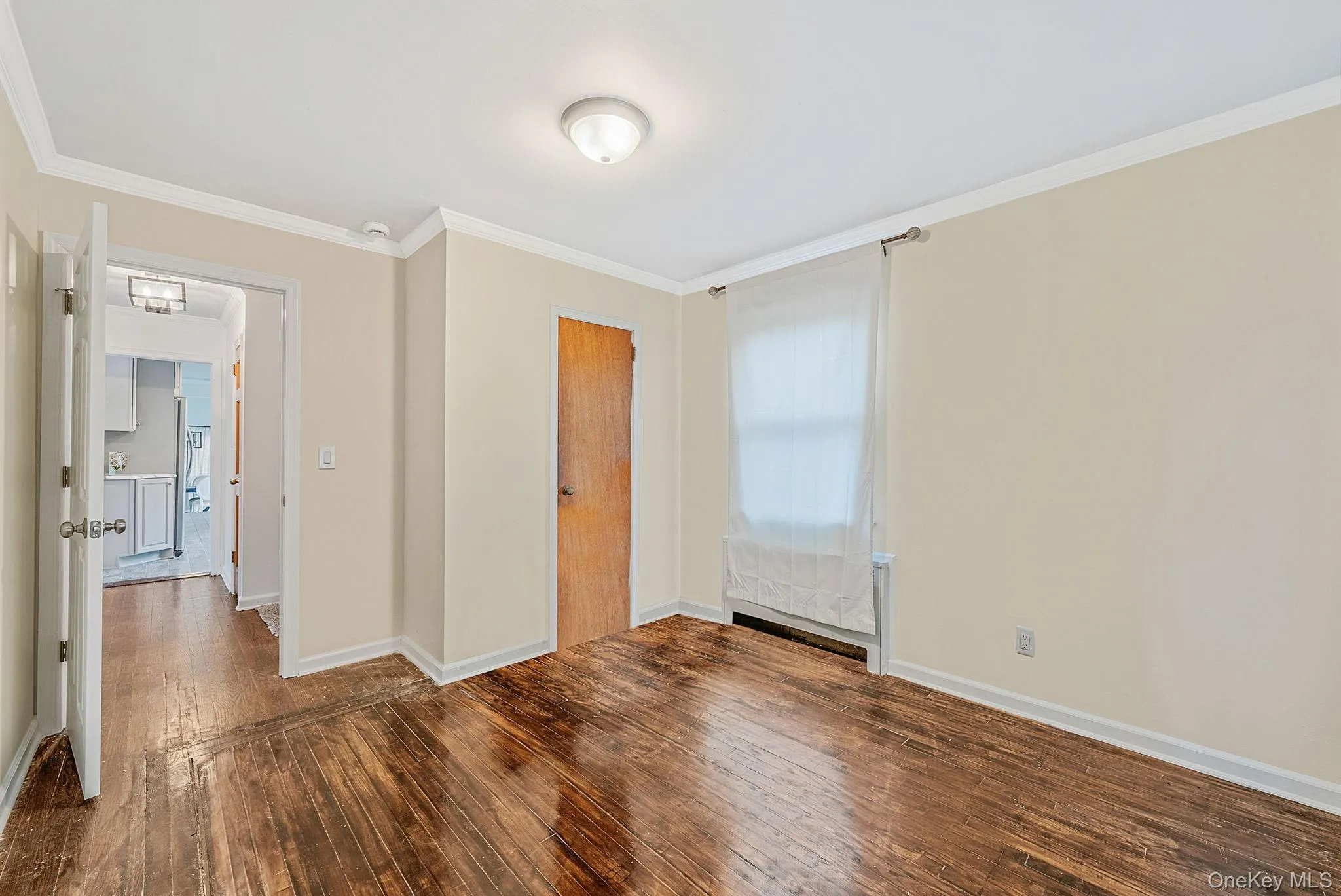Unfurnished bedroom with ornamental molding and hardwood / wood-style flooring Unfurnished bedroom with ornamental molding and hardwood / wood-style flooring