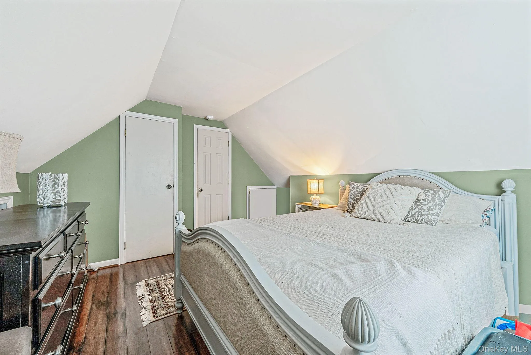 Bedroom with dark wood finished floors and lofted ceiling Bedroom with dark wood finished floors and lofted ceiling