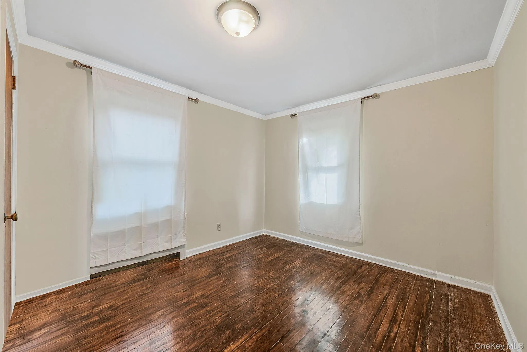 Unfurnished room featuring ornamental molding and hardwood / wood-style flooring Unfurnished room featuring ornamental molding and hardwood / wood-style flooring