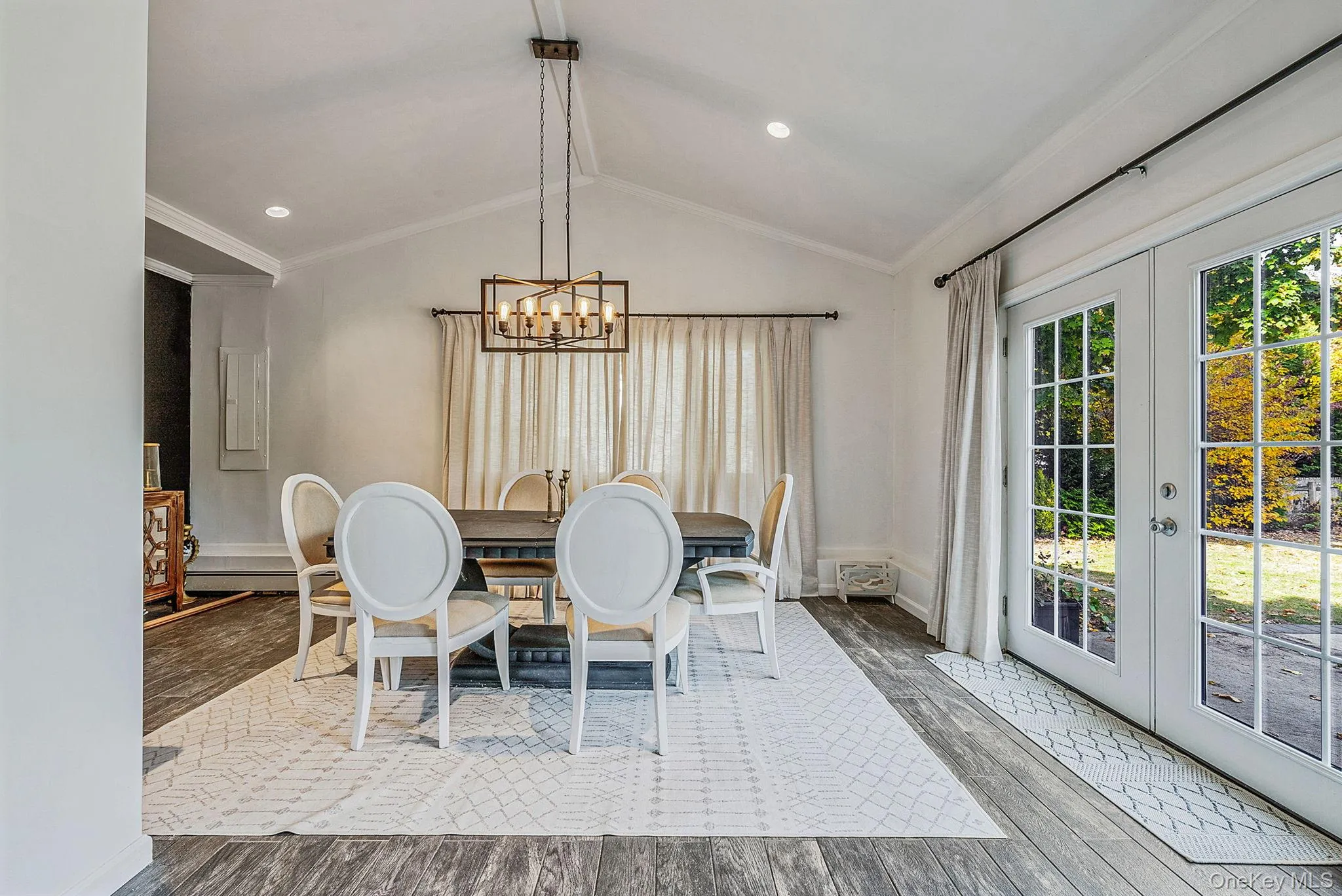 Dining room featuring crown molding, french doors, wood finished floors, vaulted ceiling, and a chandelier Dining room featuring crown molding, french doors, wood finished floors, vaulted ceiling, and a chandelier