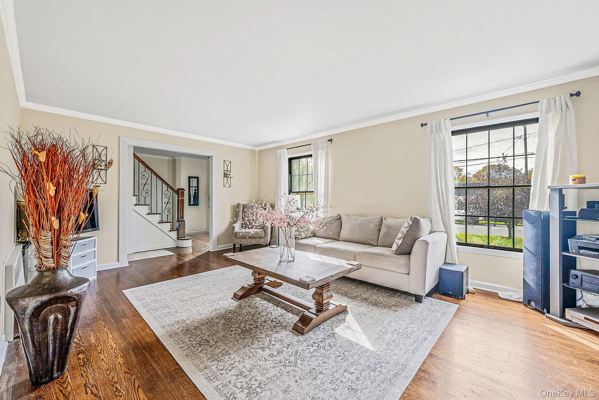 Living room featuring ornamental molding, dark wood finished floors, and stairway Living room featuring ornamental molding, dark wood finished floors, and stairway