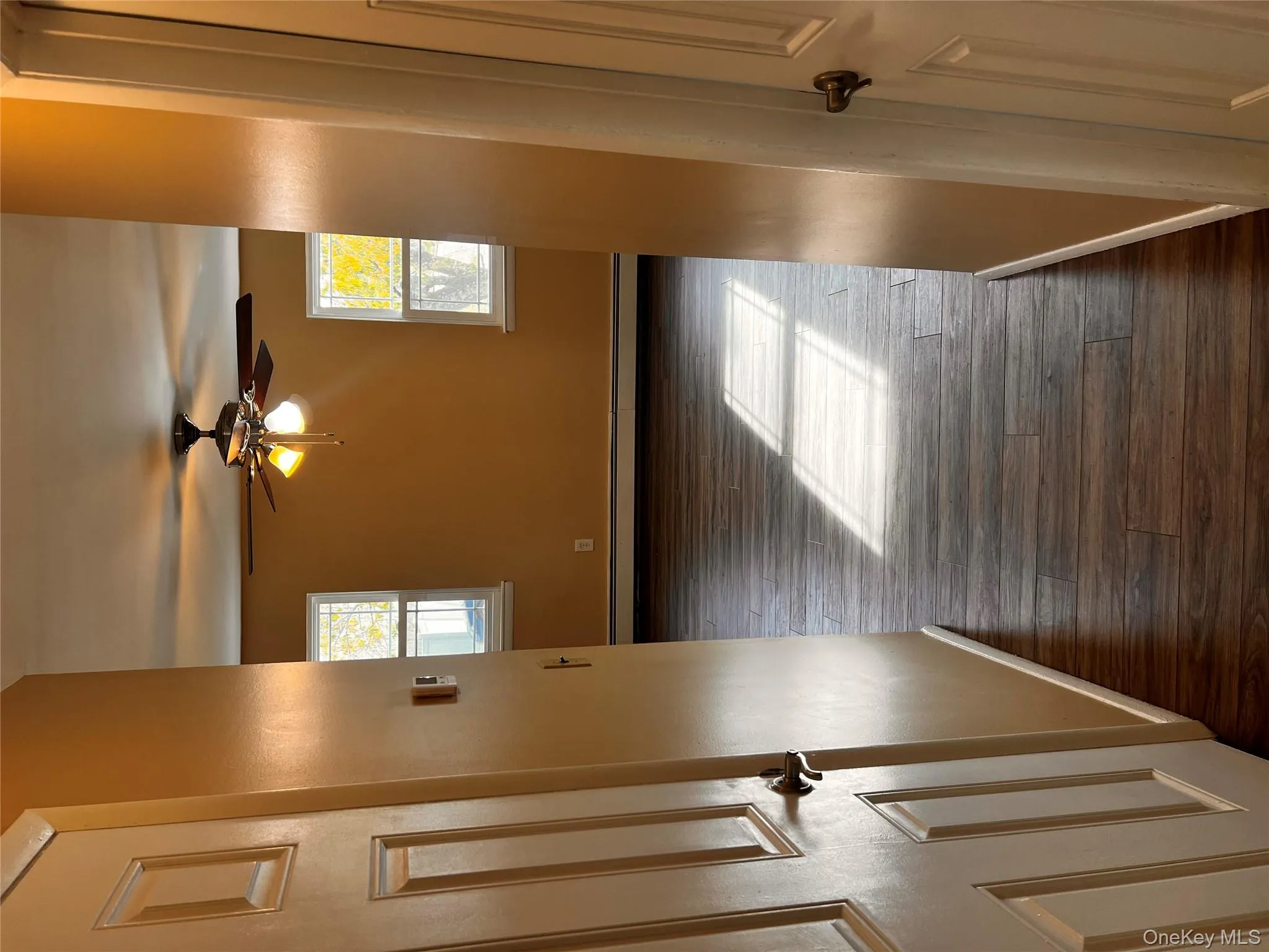 Spare room featuring dark wood-style floors, plenty of natural light, and a ceiling fan Spare room featuring dark wood-style floors, plenty of natural light, and a ceiling fan