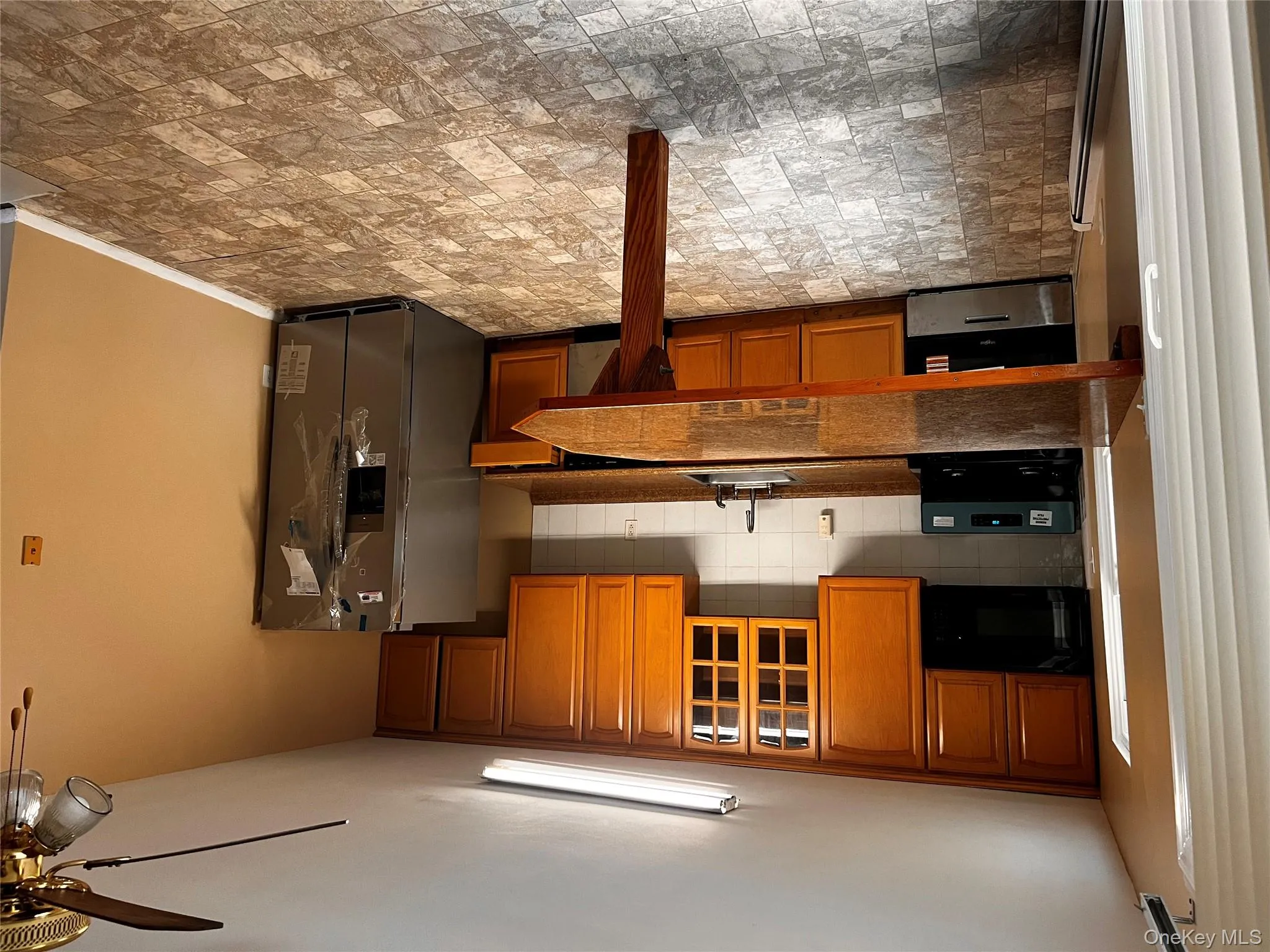 Kitchen featuring dark countertops, tasteful backsplash, brown cabinets, and stove Kitchen featuring dark countertops, tasteful backsplash, brown cabinets, and stove