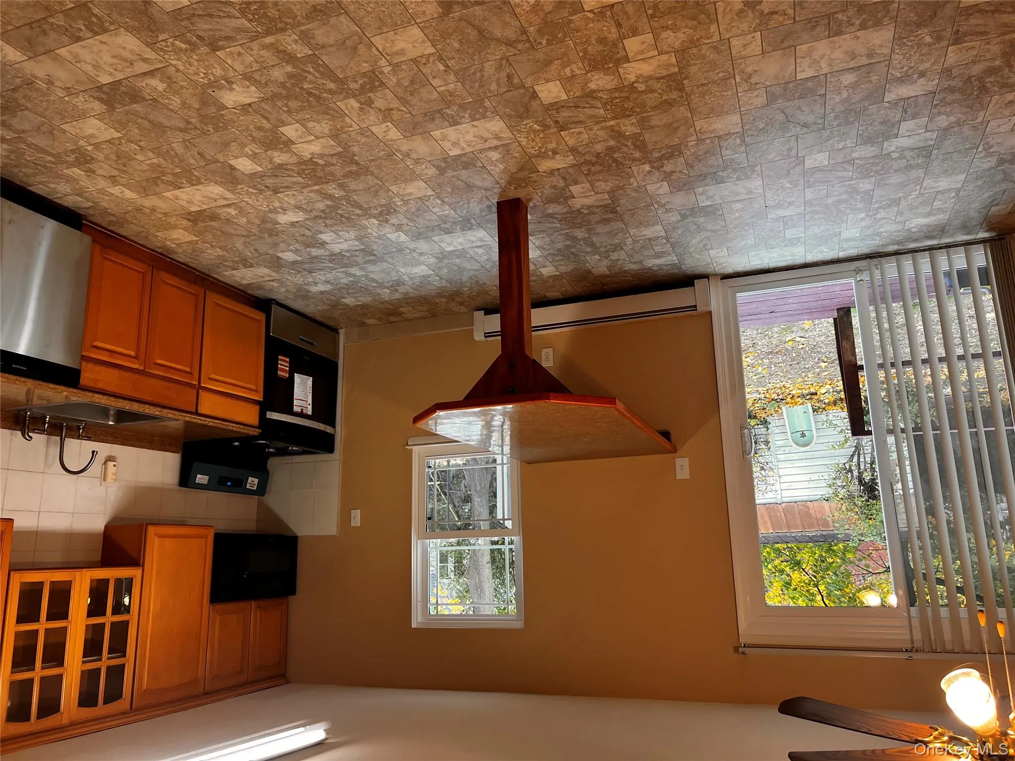 Kitchen with stove, stone finish flooring, dishwasher, tasteful backsplash, and glass insert cabinets Kitchen with stove, stone finish flooring, dishwasher, tasteful backsplash, and glass insert cabinets