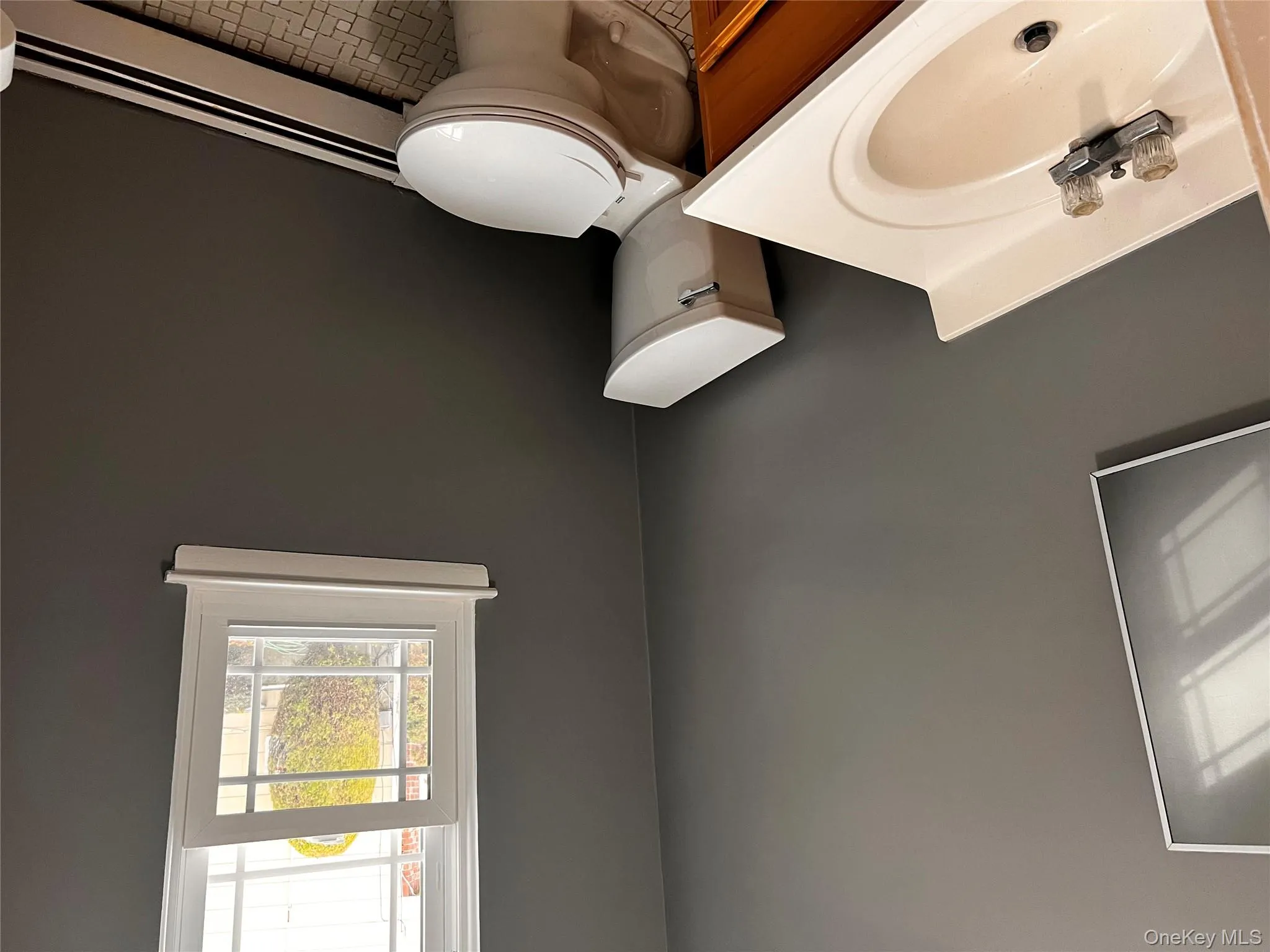 Half bath featuring baseboard heating, vanity, and light tile patterned floors Half bath featuring baseboard heating, vanity, and light tile patterned floors