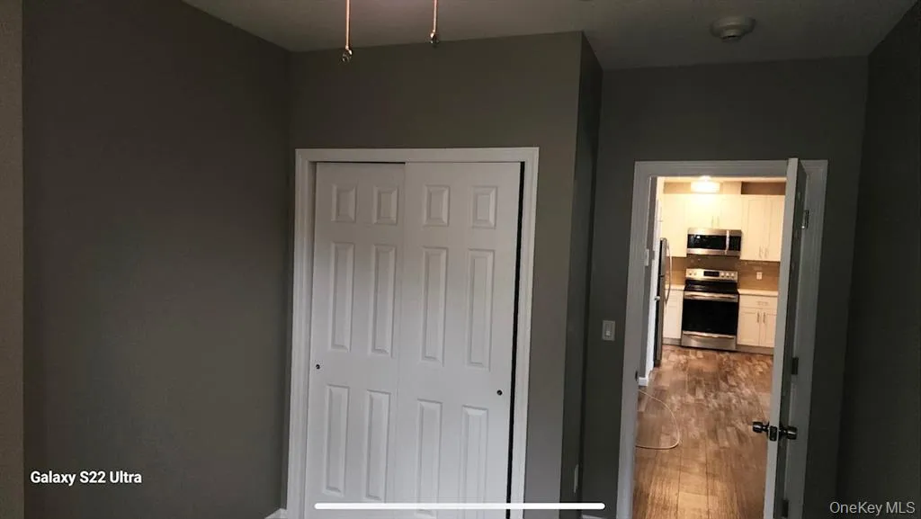 Unfurnished bedroom with dark wood finished floors and a closet Unfurnished bedroom with dark wood finished floors and a closet