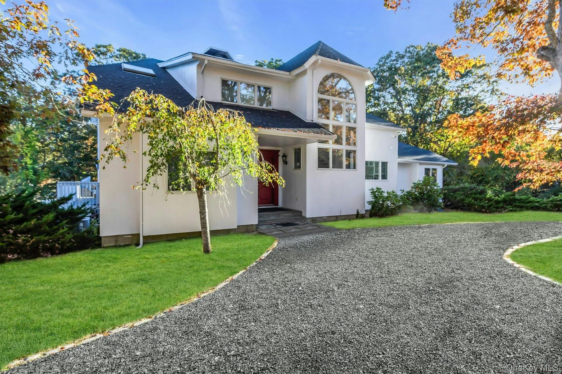 View of front of property with a front yard, a shingled roof, and stucco siding View of front of property with a front yard, a shingled roof, and stucco siding