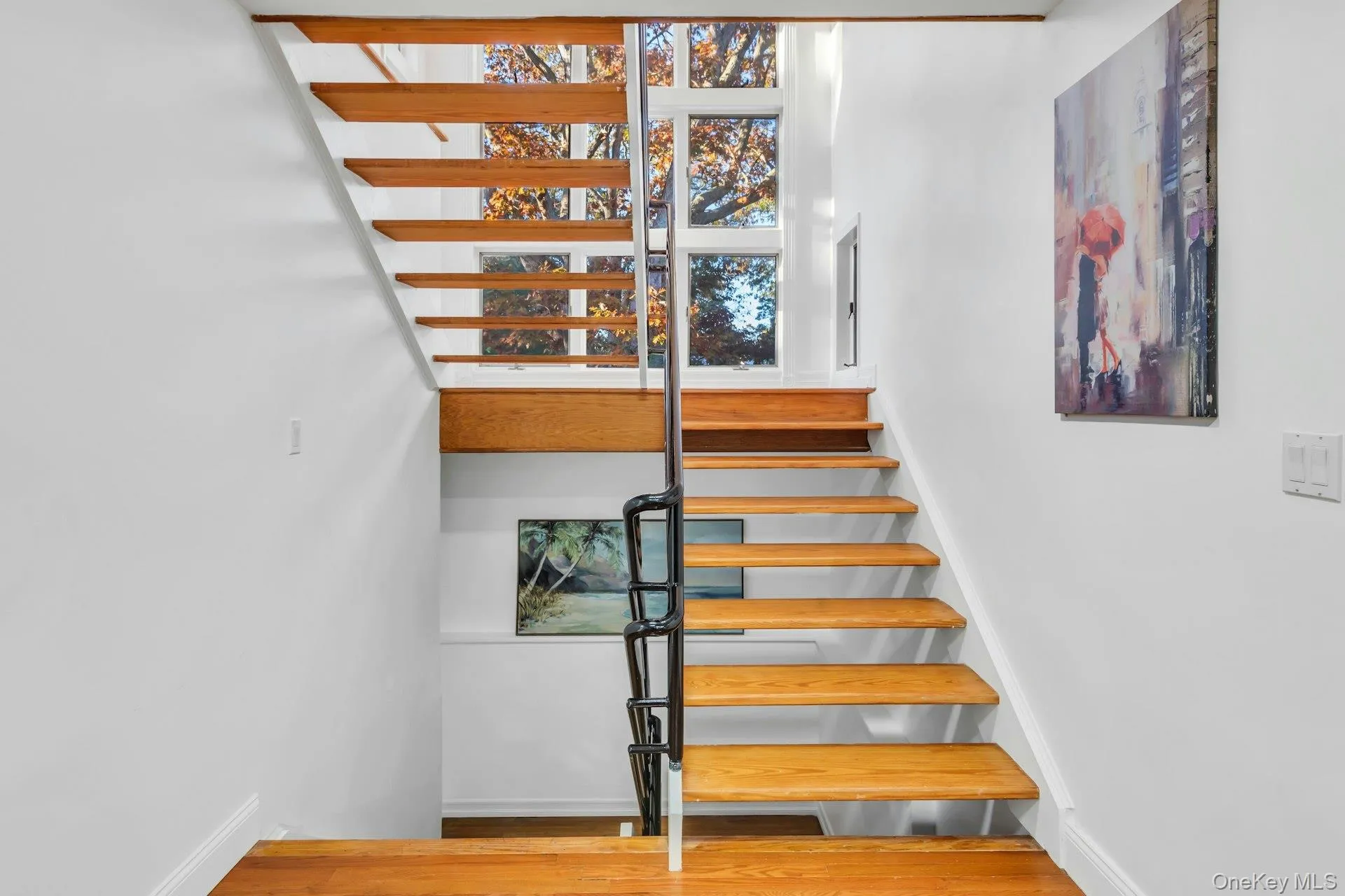 Stairs featuring wood finished floors and baseboards Stairs featuring wood finished floors and baseboards