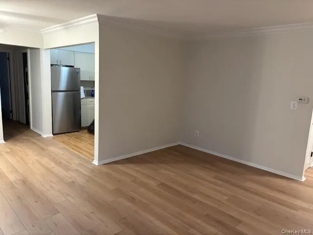 Unfurnished room with light wood-type flooring and crown molding Unfurnished room with light wood-type flooring and crown molding