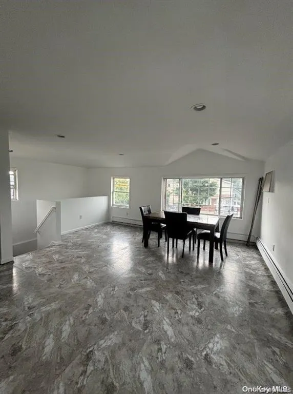 Dining space with a baseboard heating unit, vaulted ceiling, and baseboard heating Dining space with a baseboard heating unit, vaulted ceiling, and baseboard heating