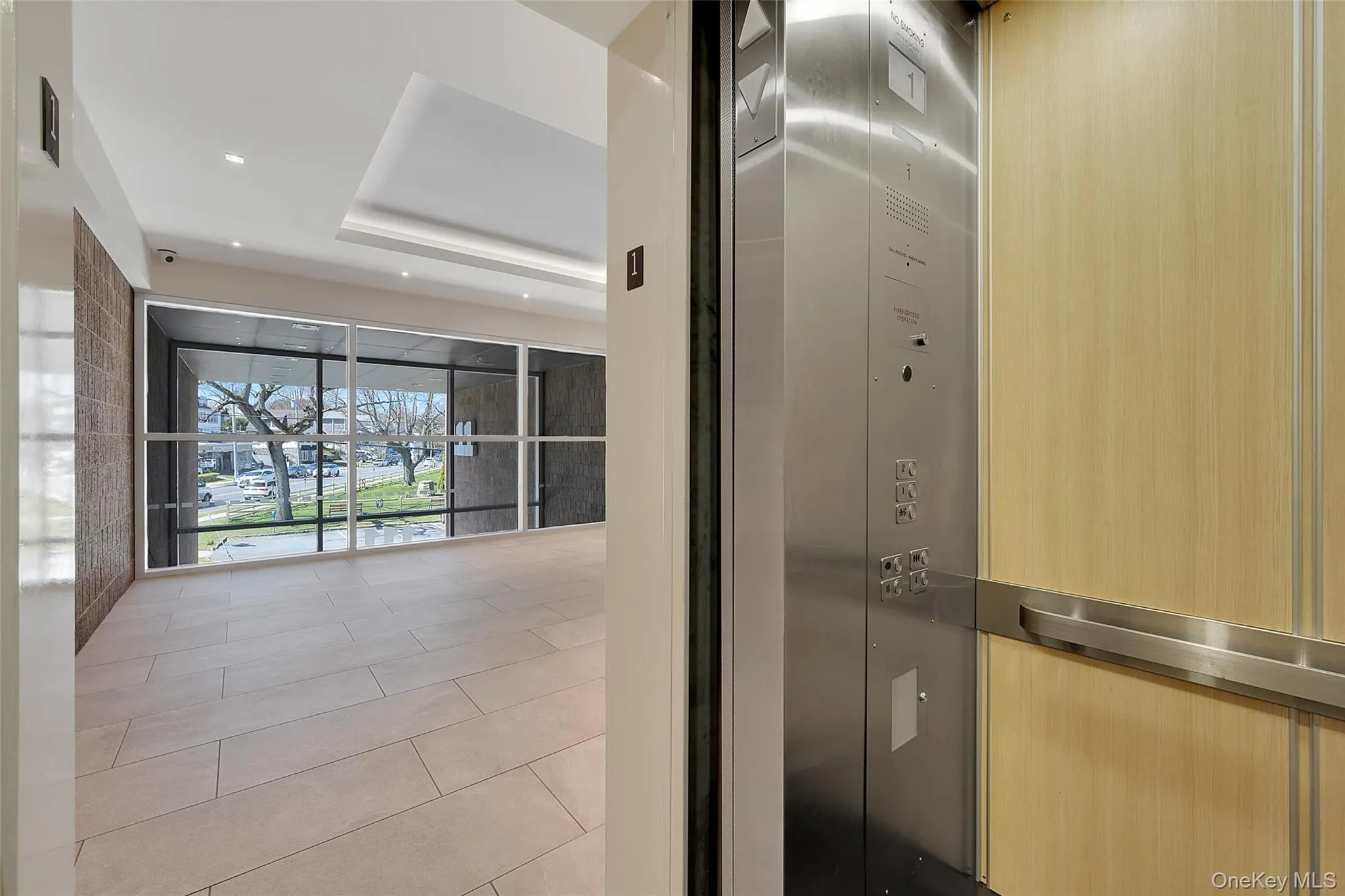 Hallway featuring light tile patterned flooring, elevator, and recessed lighting Hallway featuring light tile patterned flooring, elevator, and recessed lighting