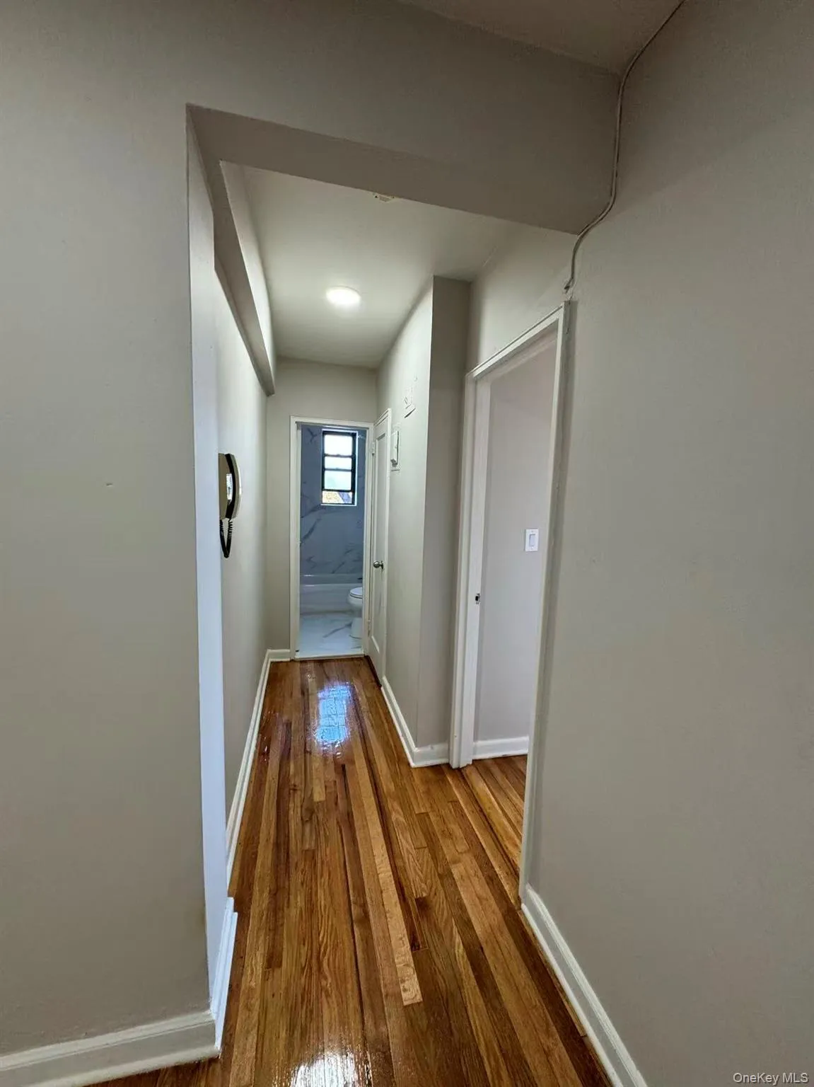 Hallway featuring hardwood / wood-style flooring and baseboards Hallway featuring hardwood / wood-style flooring and baseboards
