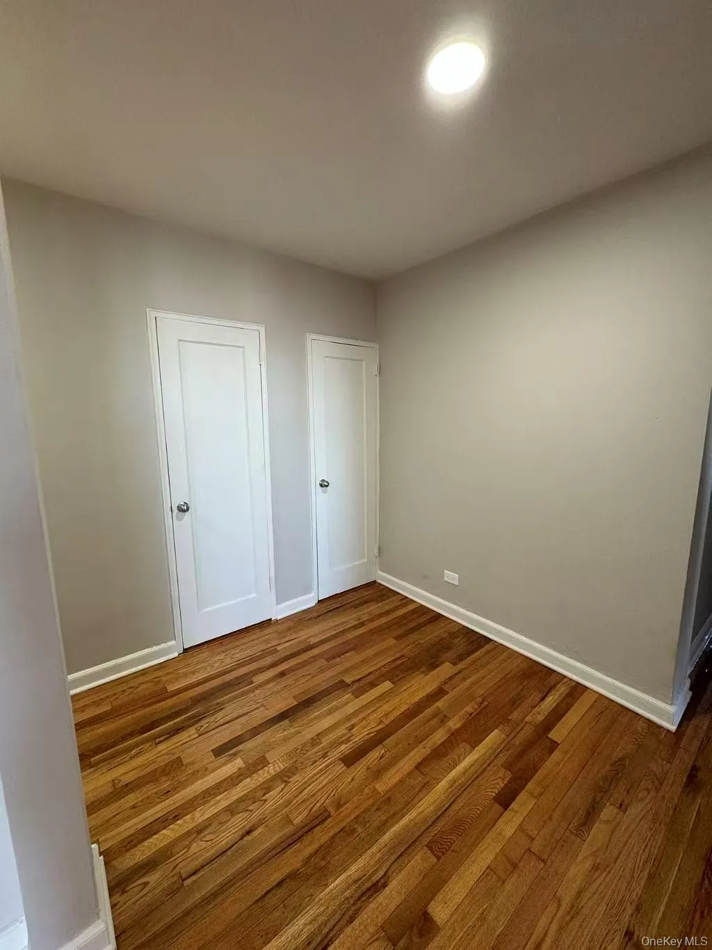 Unfurnished bedroom featuring wood finished floors and baseboards Unfurnished bedroom featuring wood finished floors and baseboards