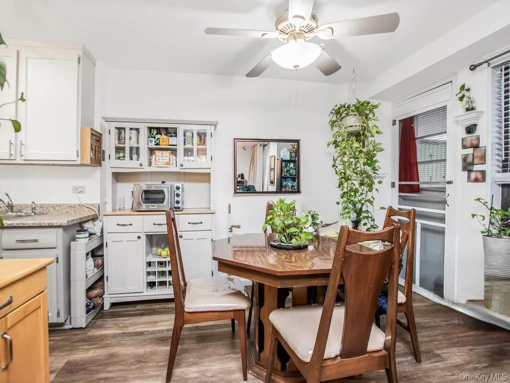 Dining area featuring dark wood-style floors and a ceiling fan Dining area featuring dark wood-style floors and a ceiling fan