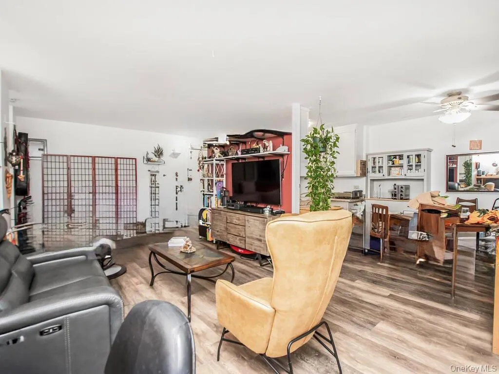 Living area featuring light wood finished floors and a ceiling fan Living area featuring light wood finished floors and a ceiling fan