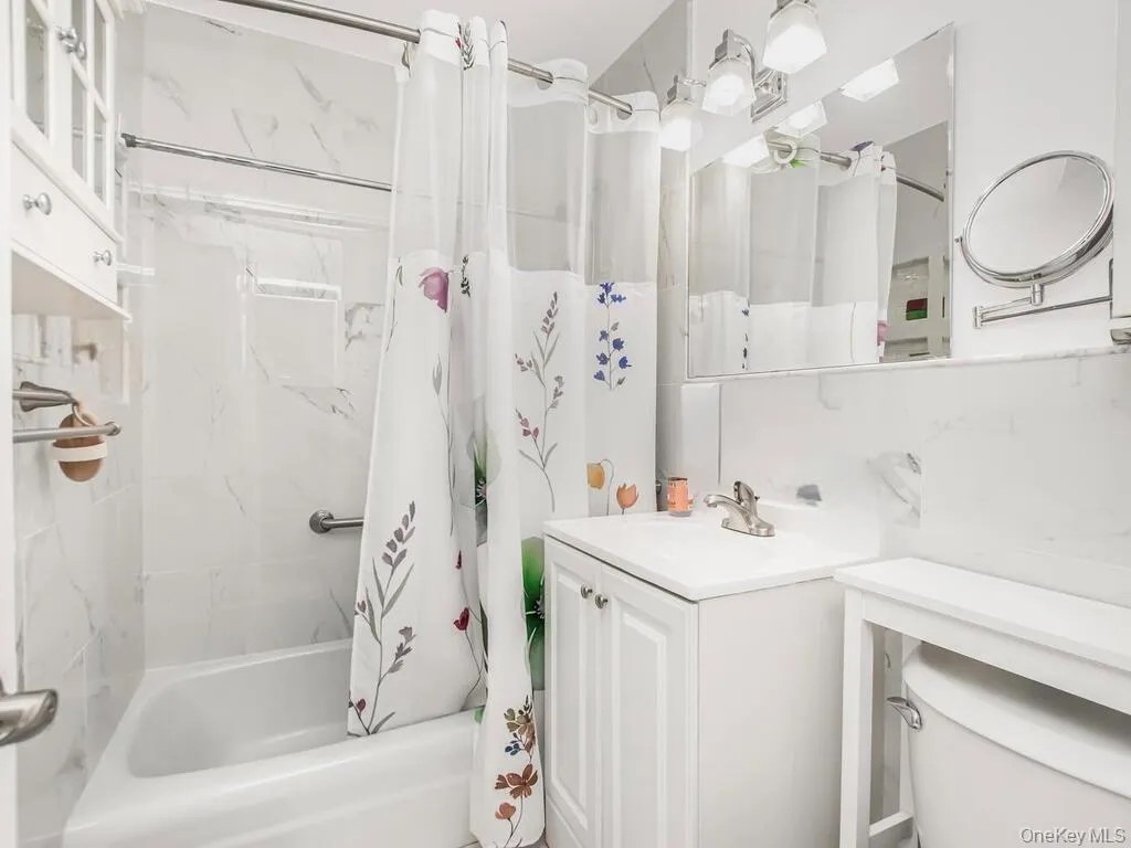 Bathroom featuring vanity and shower / tub combo with curtain Bathroom featuring vanity and shower / tub combo with curtain