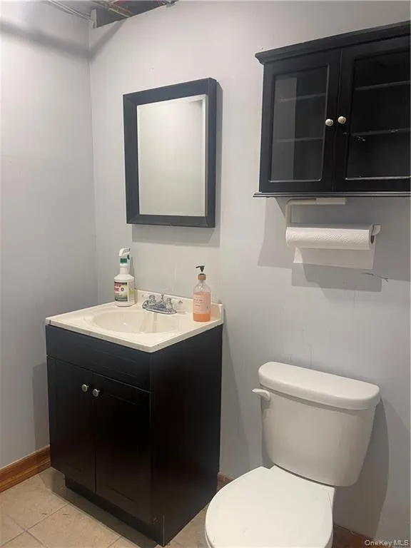 Half bathroom with vanity and light tile patterned flooring Half bathroom with vanity and light tile patterned flooring