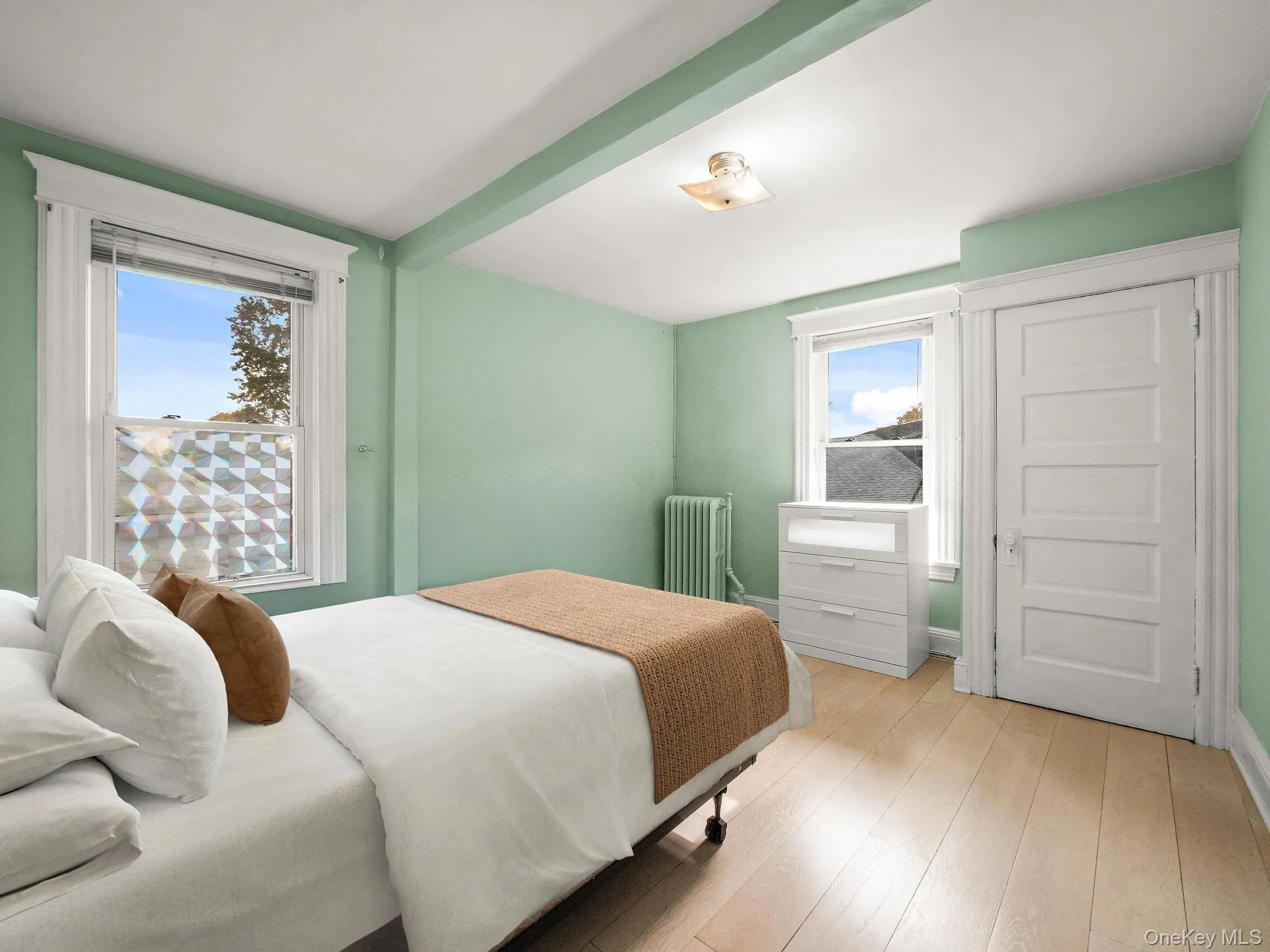Bedroom featuring wood finished floors and radiator Bedroom featuring wood finished floors and radiator