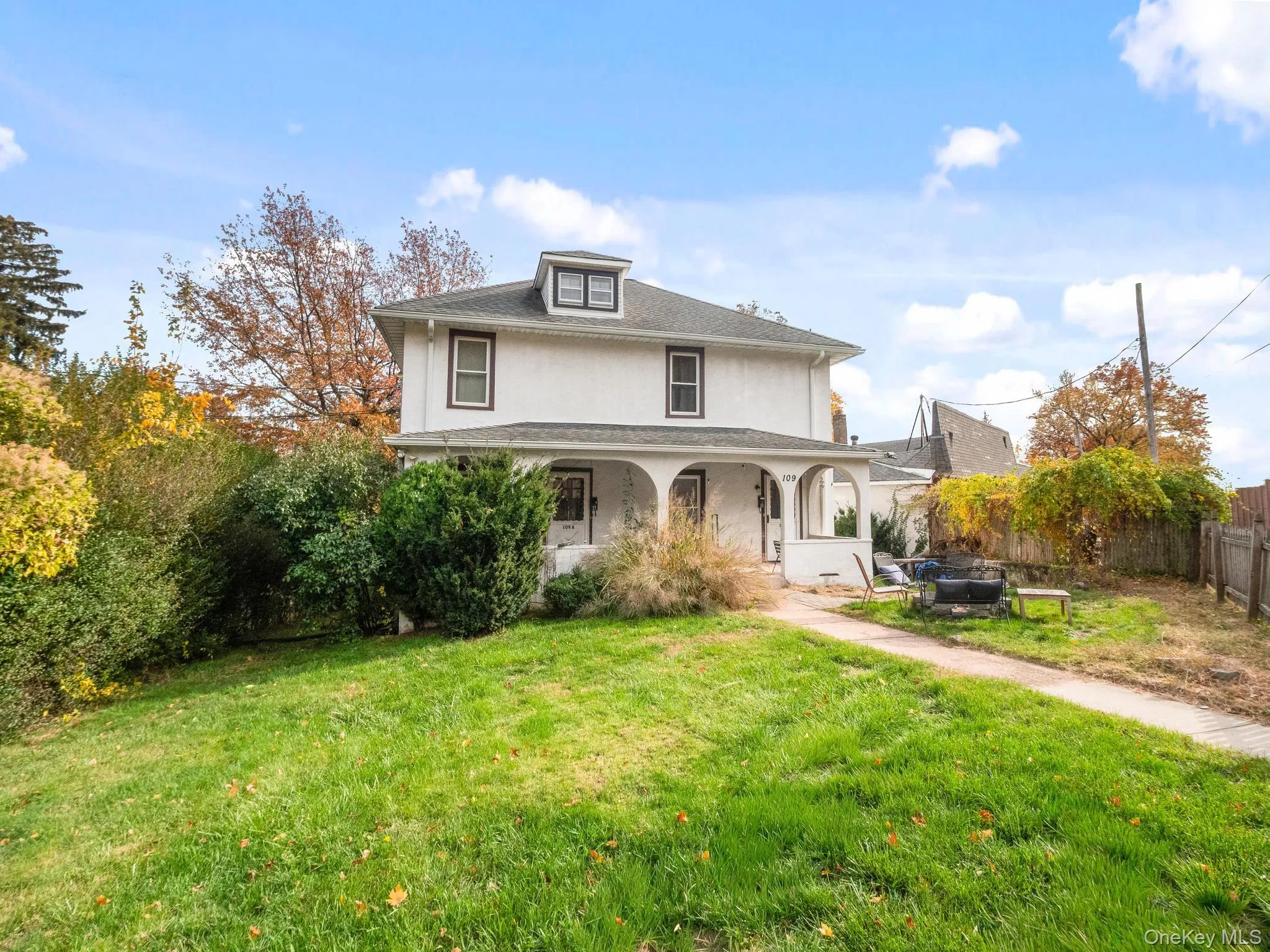 American foursquare style home featuring covered porch and stucco siding American foursquare style home featuring covered porch and stucco siding