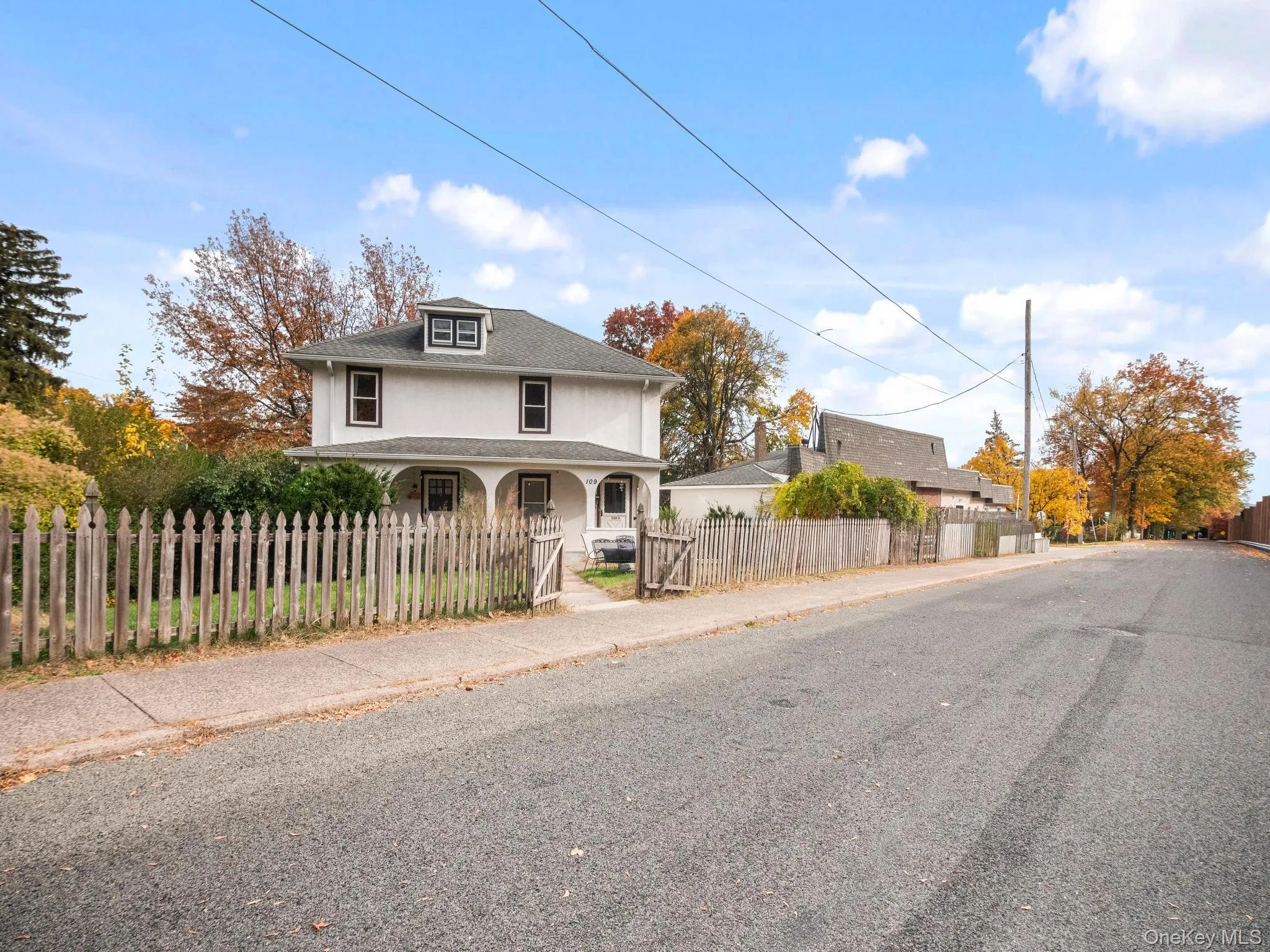 View of front of house featuring a fenced front yard, a porch, stucco siding, and a gate View of front of house featuring a fenced front yard, a porch, stucco siding, and a gate