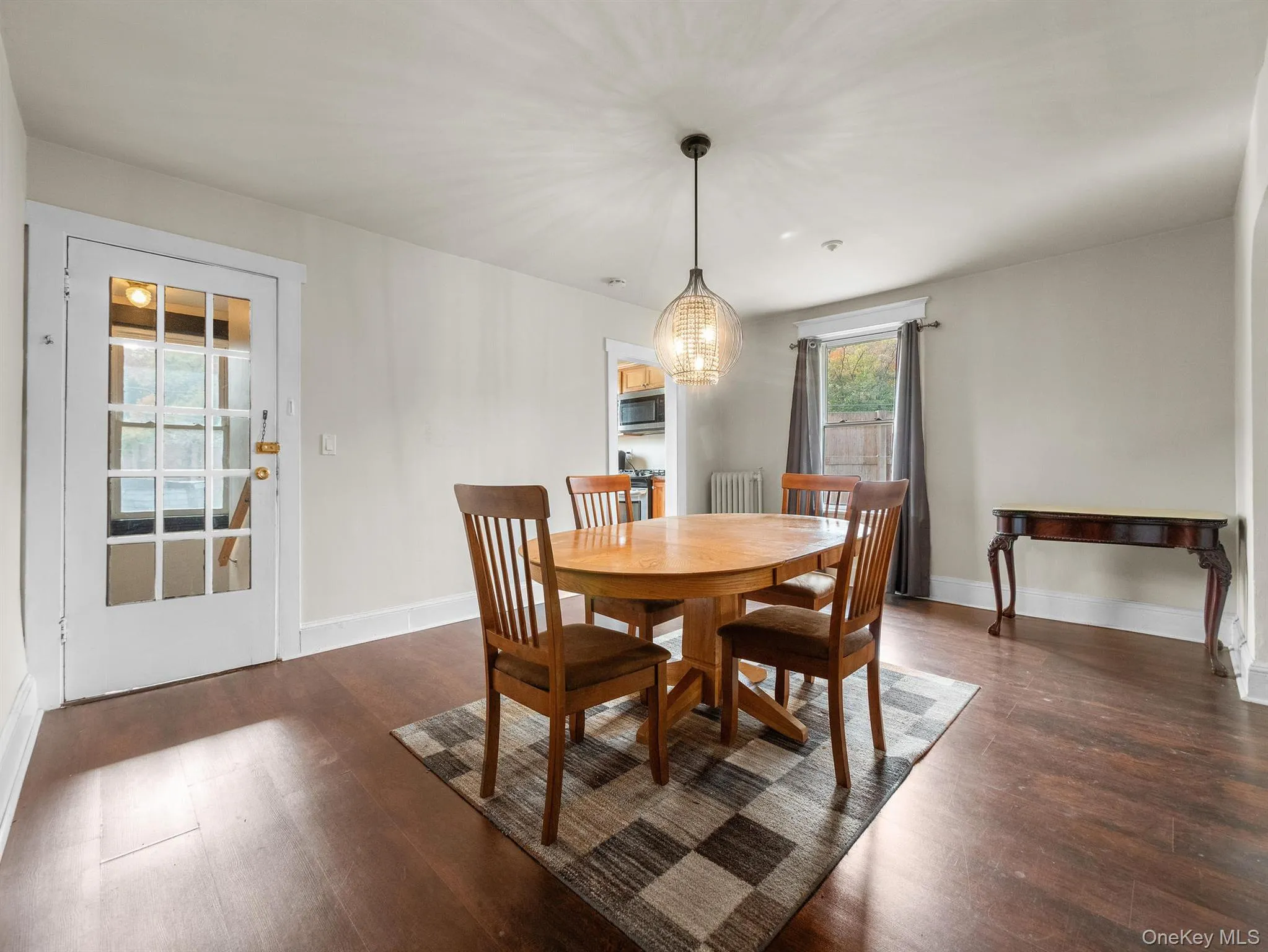 Dining area featuring dark wood finished floors and radiator heating unit Dining area featuring dark wood finished floors and radiator heating unit