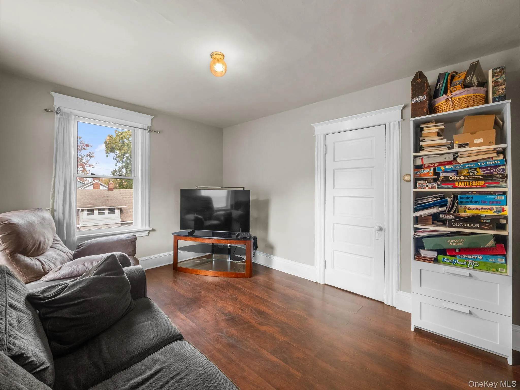 Living room featuring dark wood finished floors and baseboards Living room featuring dark wood finished floors and baseboards