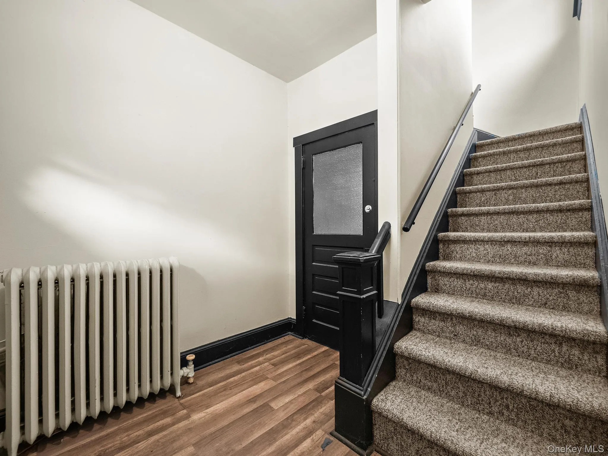 Stairway with radiator heating unit and wood finished floors Stairway with radiator heating unit and wood finished floors