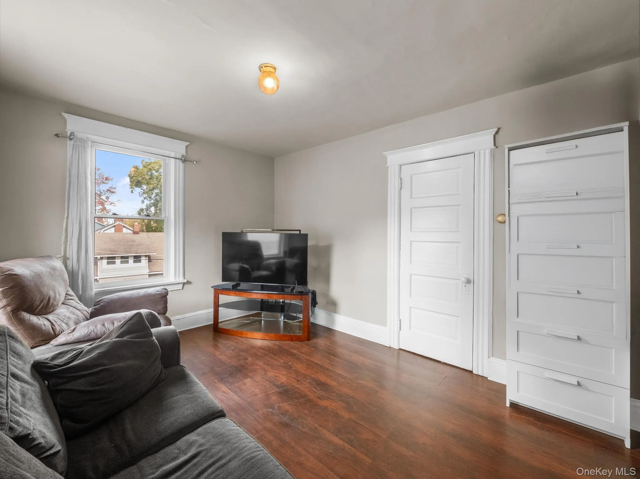 Living room with baseboards and dark wood finished floors Living room with baseboards and dark wood finished floors