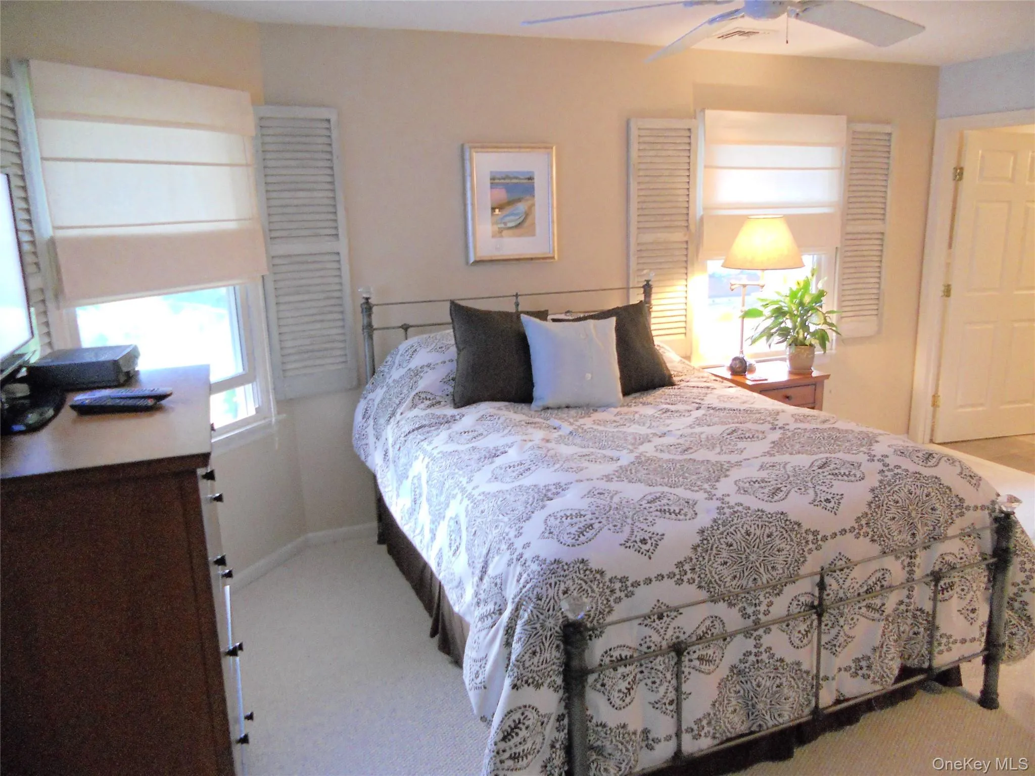 Bedroom with light carpet and a ceiling fan Bedroom with light carpet and a ceiling fan